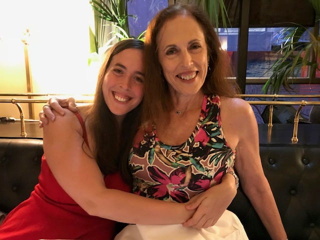 An adult daughter embracing her mother