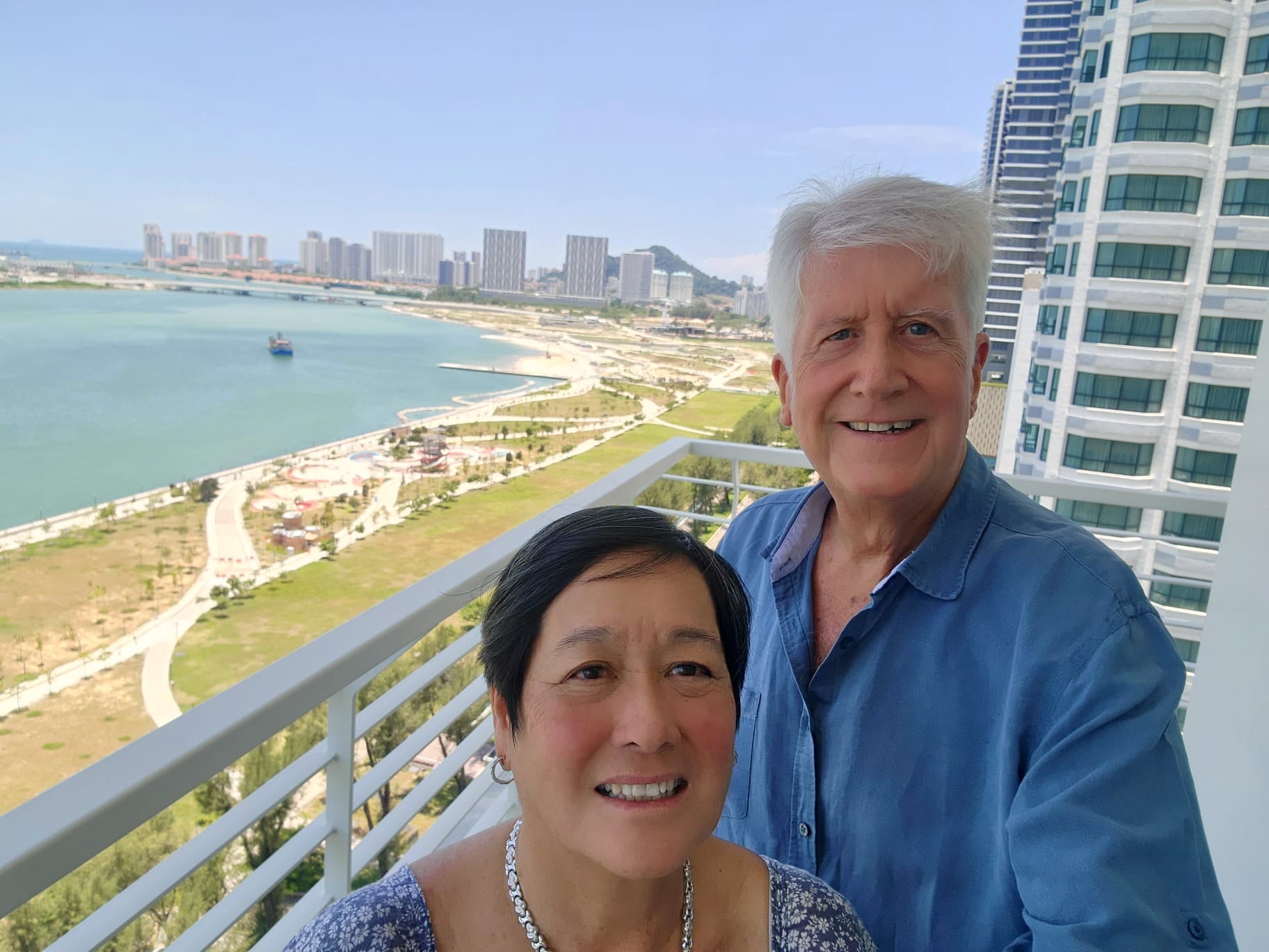 A retired couple posing for a selfie on their balcony in Penang, Malaysia.