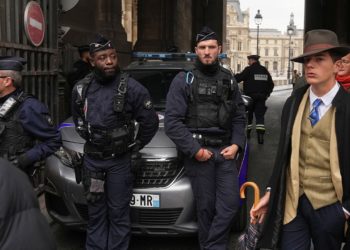 Mystery man in dapper suit goes viral after appearing in Louvre heist investigation photo
