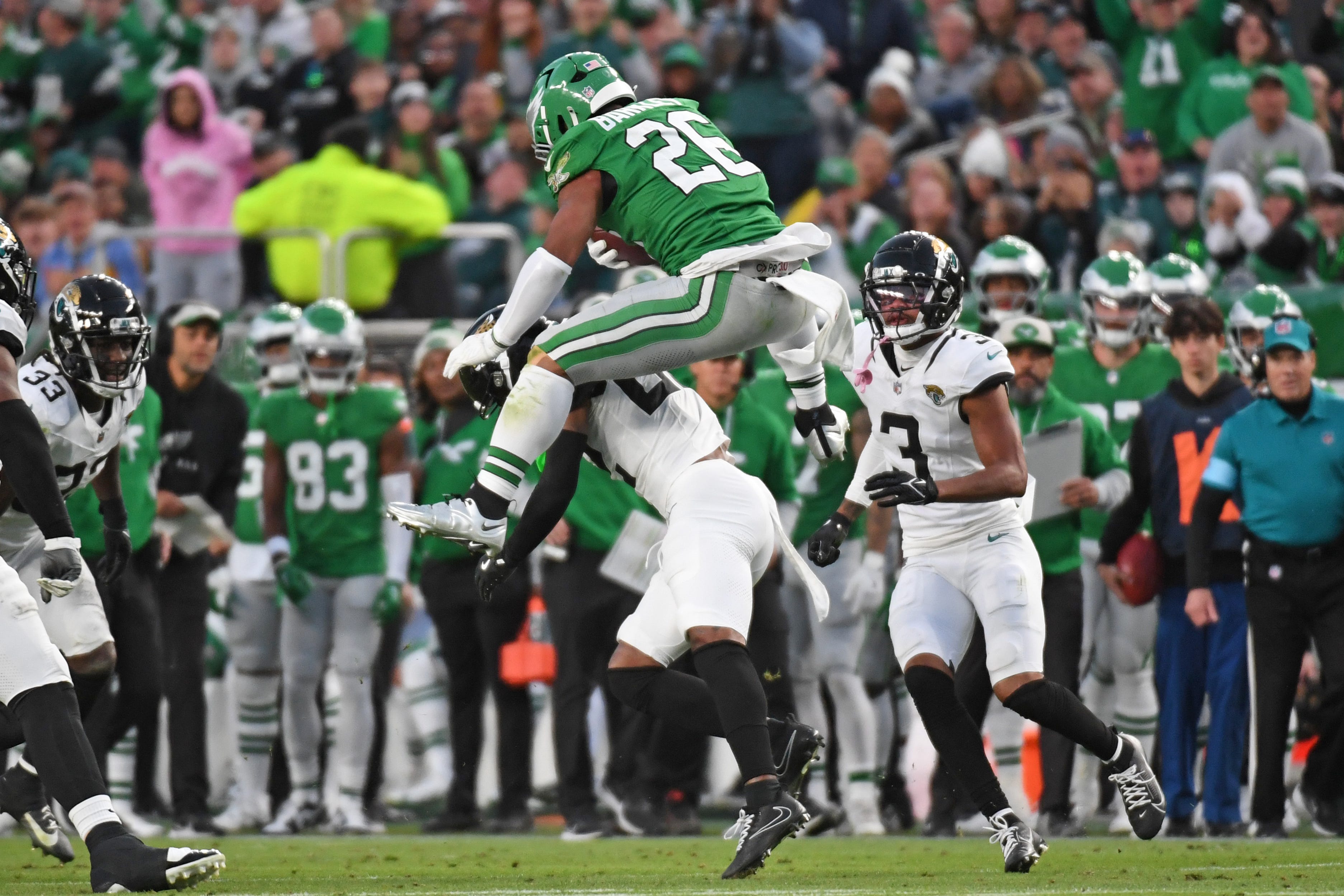 Philadelphia Eagles running back Saquon Barkley jumps over a Jacksonville Jaguars cornerback.