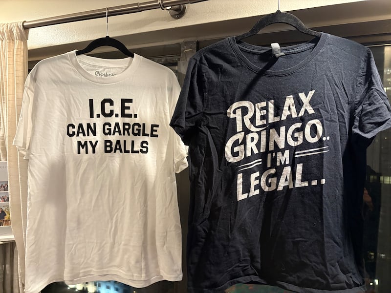 Two t-shirts. One on left is white that reads