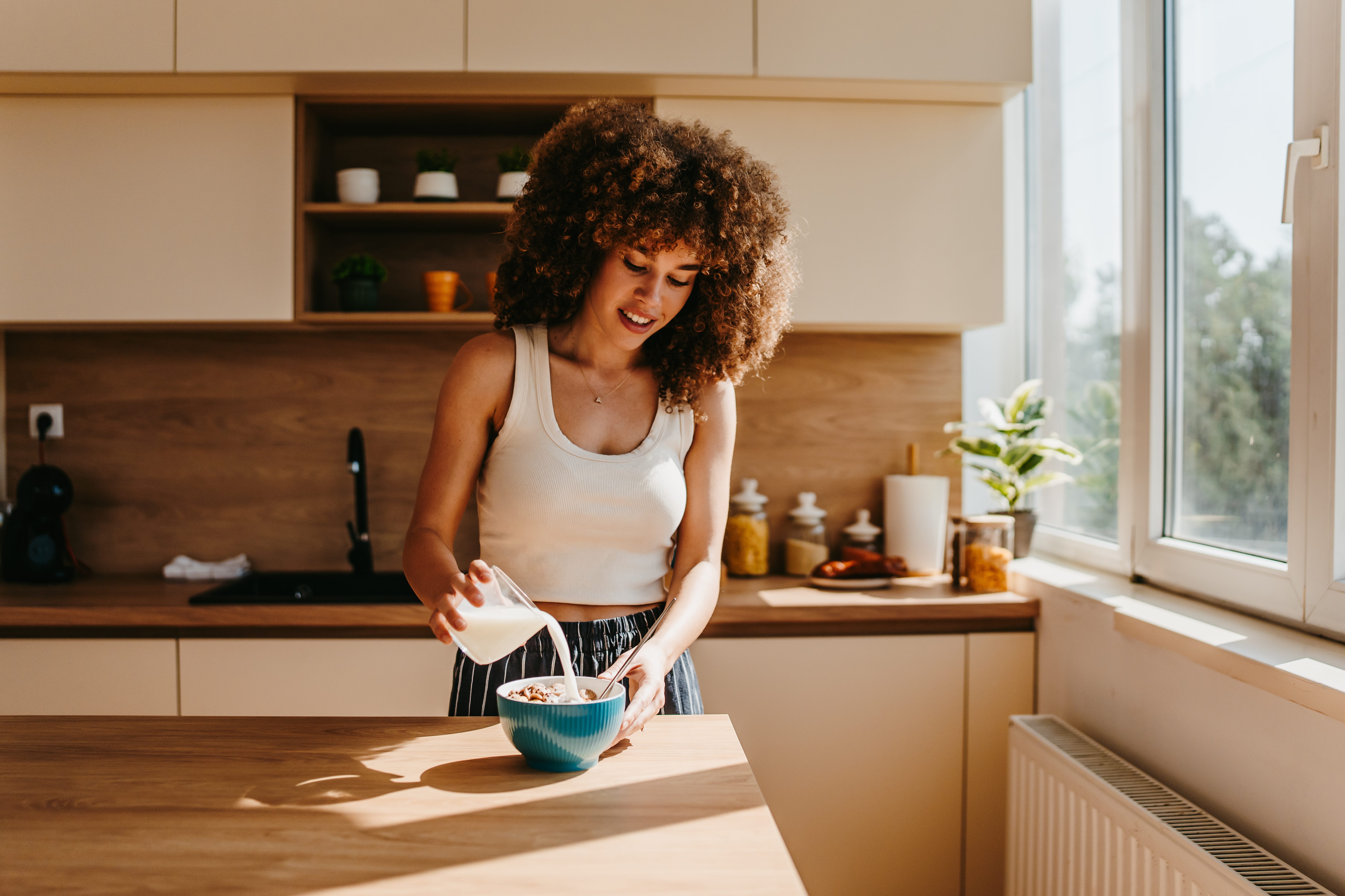 A woman prepares a nutritious breakfast in a modern kitchen.