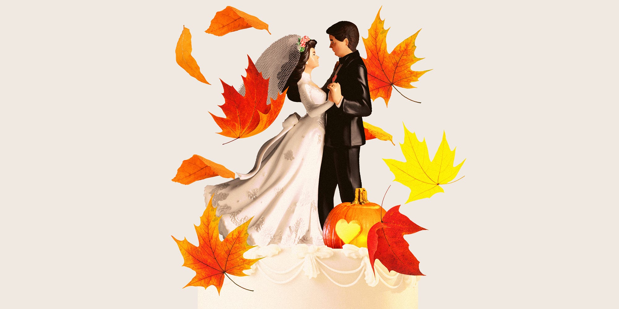 Wedding cake with dancing cake toppers, featuring a pumpkin with a carved heart, surrounded by falling leaves.
