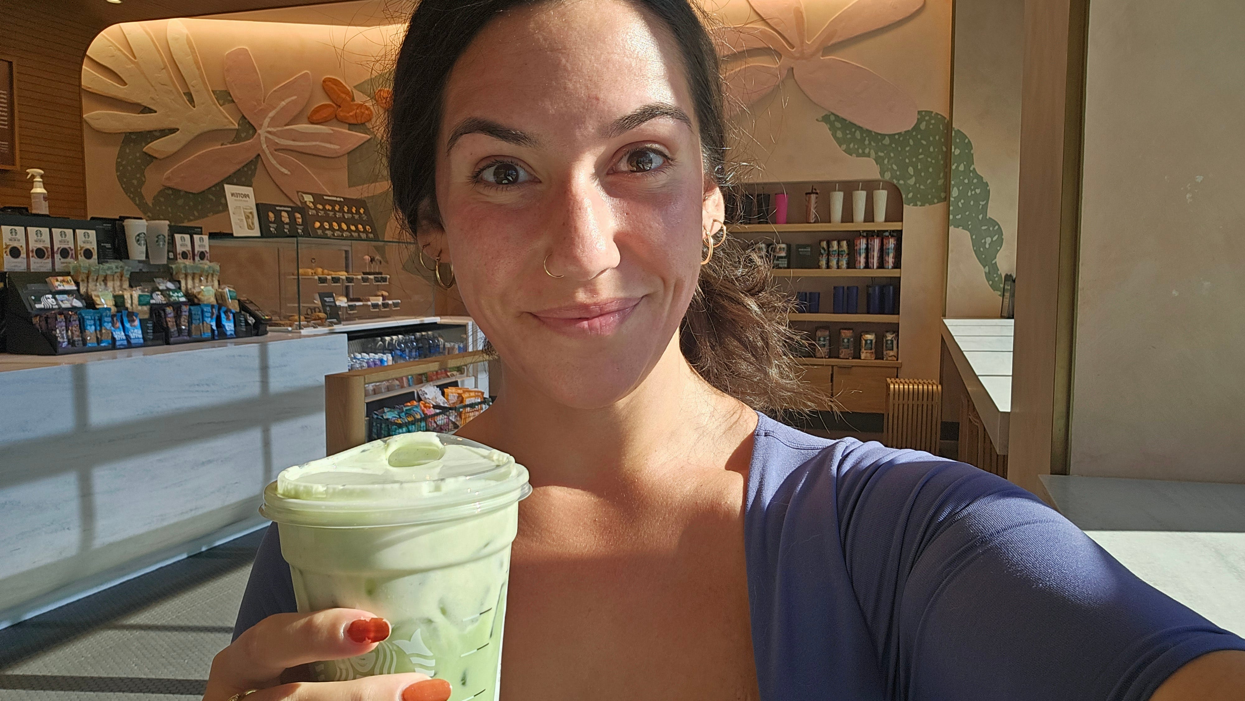 The author smiles at the camera while drinking a Starbucks protein cold foam drink