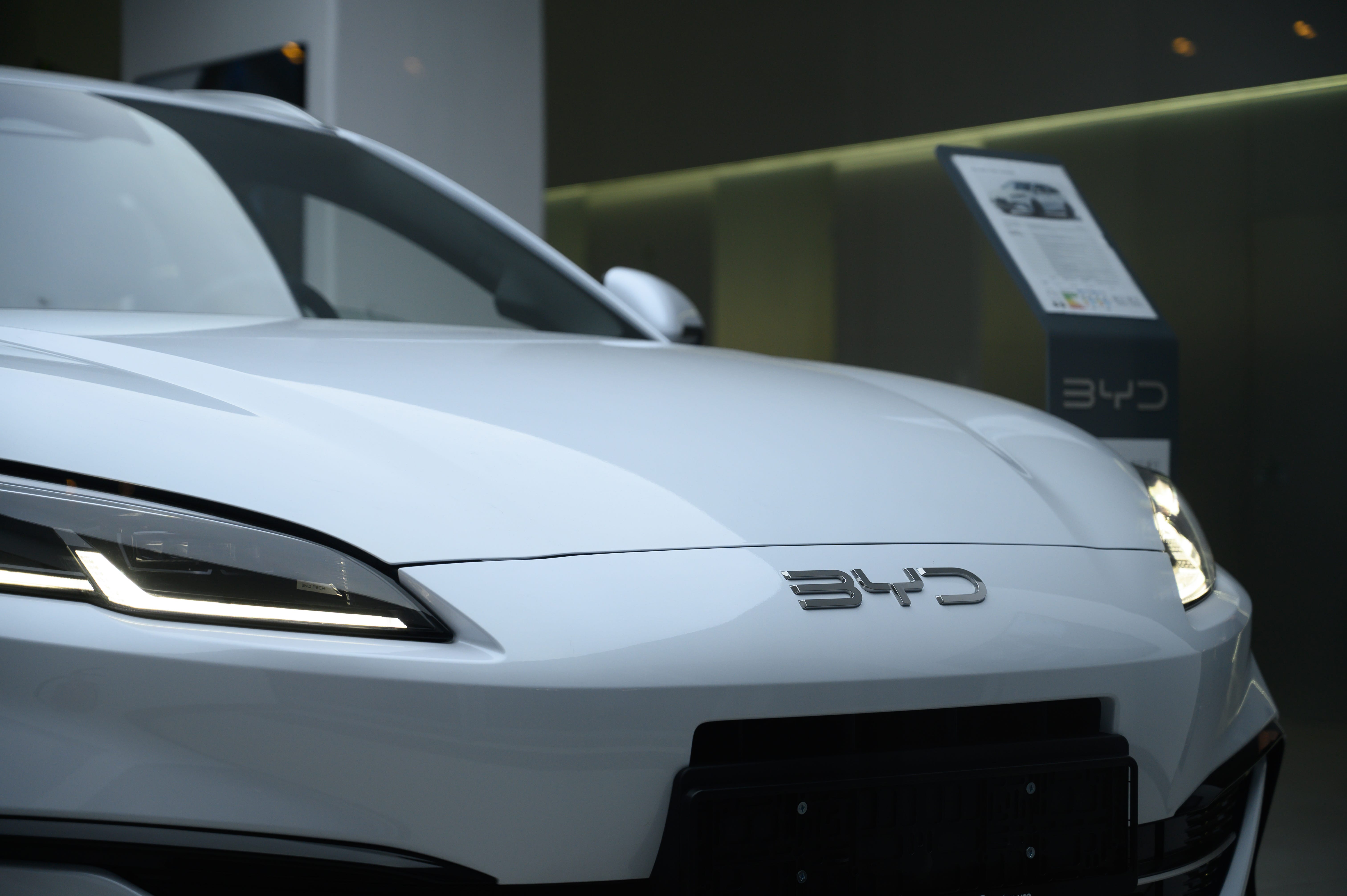 A white BYD electric vehicle on display in Warsaw, Poland.
