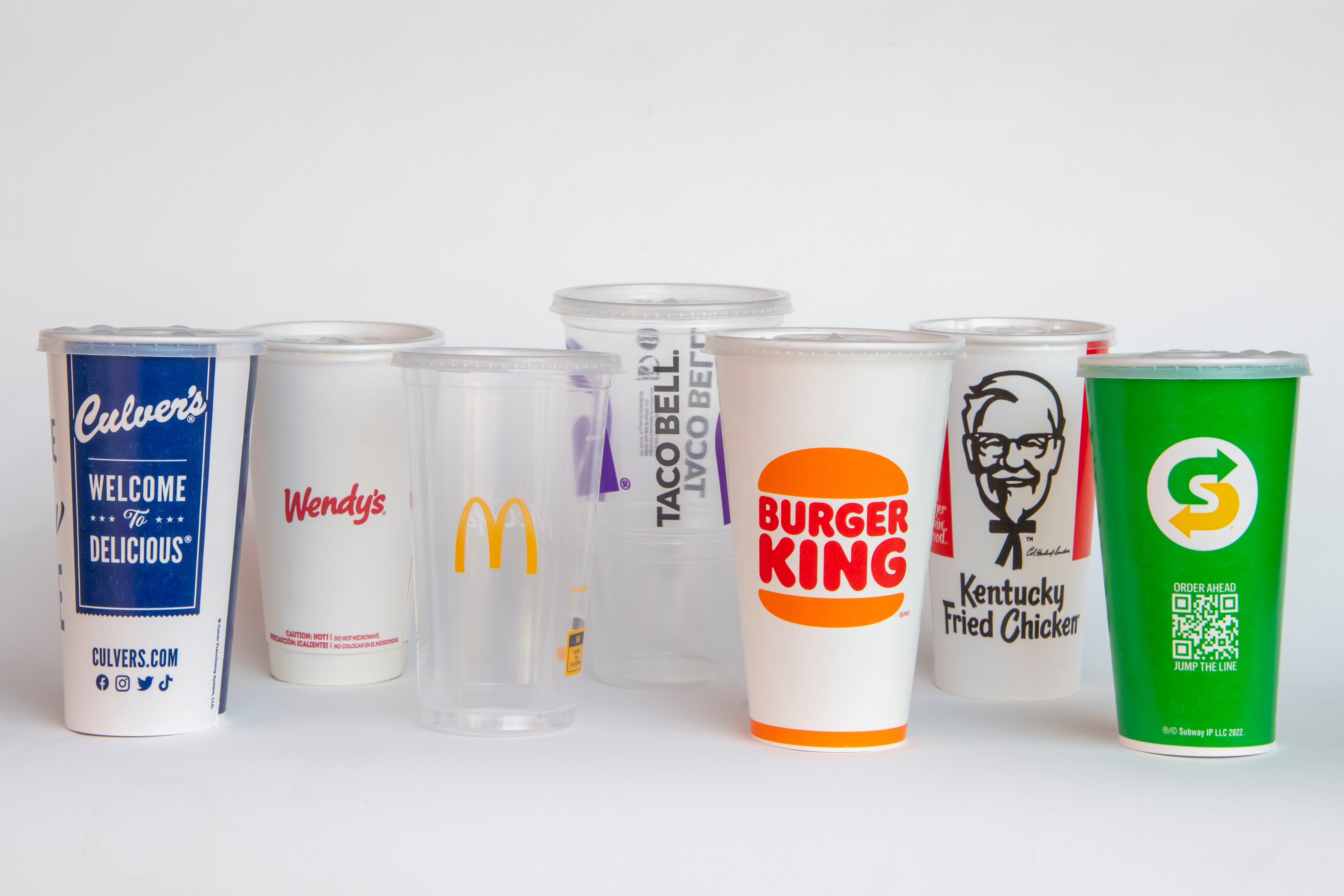 A line up of fast food beverage cups from brands including Wendy's, Taco Bell, and Burger King.