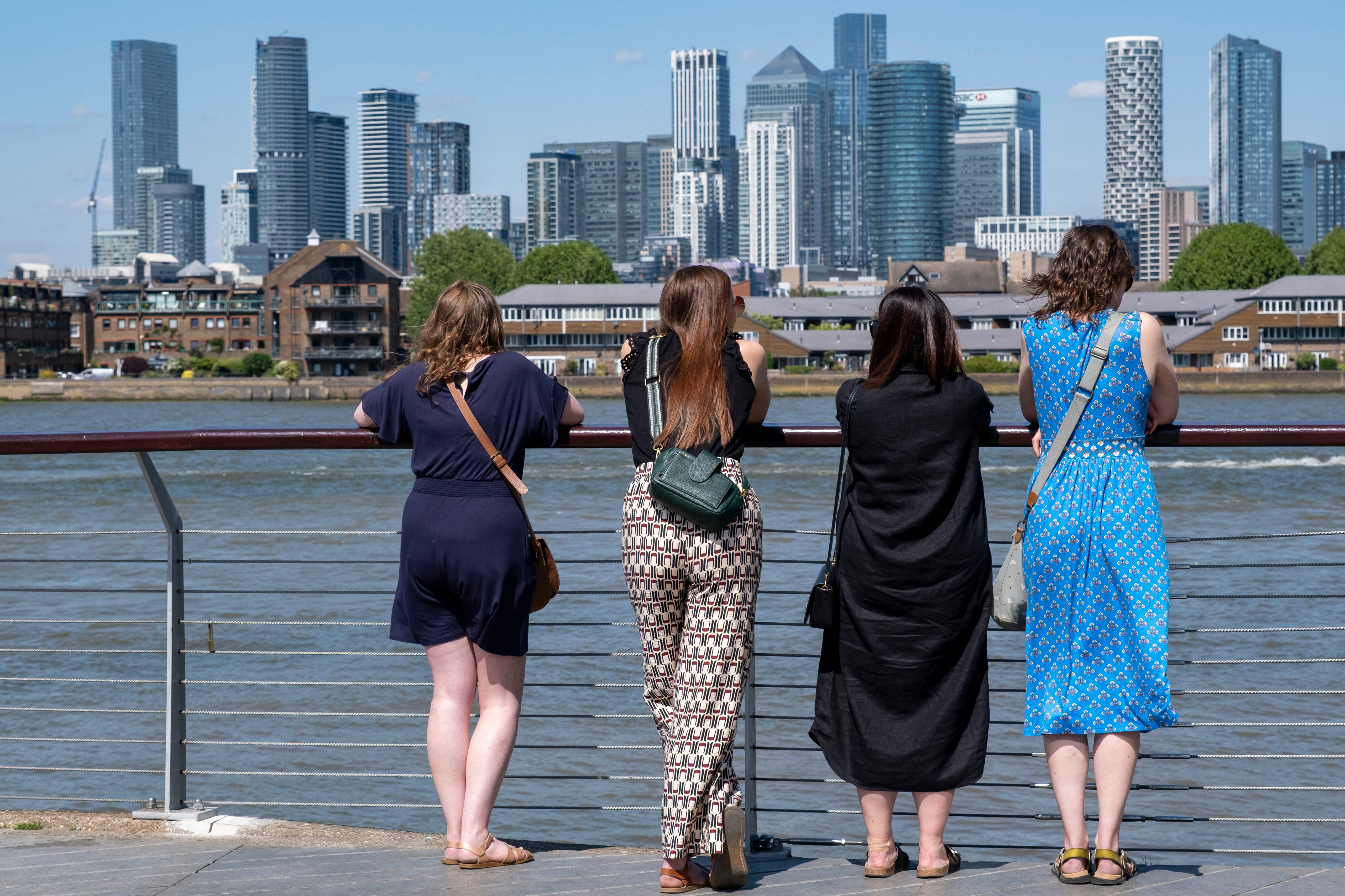 Tourists view Canary Wharf's financial district across the River Thames at Greenwich in London on May 10, 2025.