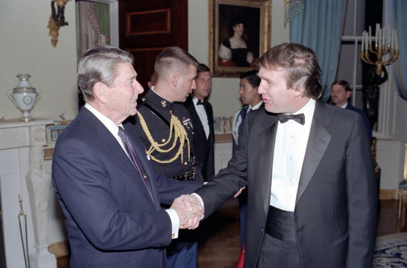US President Ronald Reagan (1911 - 2004) shakes hands with real estate developer Donald Trump in a reception line in the White House's Blue Room, Washington DC. November 3, 1987.