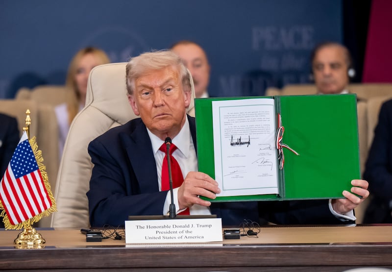 President Donald Trump holding up a signed document during the summit on ending the war in Gaza hosted by Egypt on October 13.