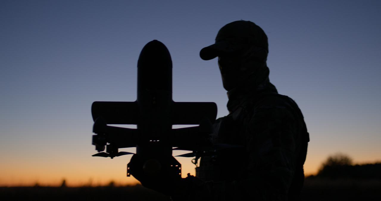Ukrainian holds the Sting, their face shrouded in shadow as the sun dips over the horizon.