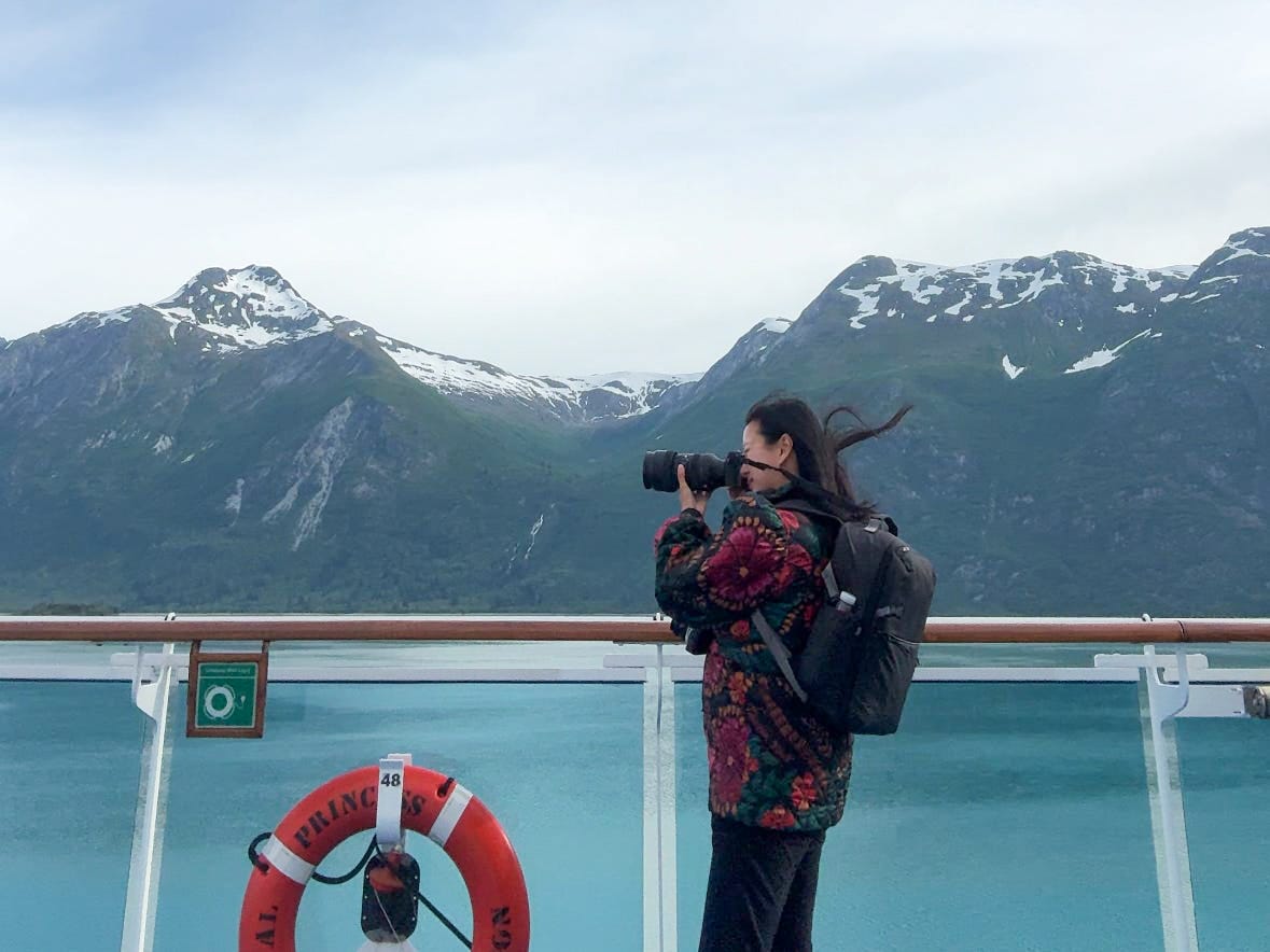 A wide shot of the author taking photos on the cruise.