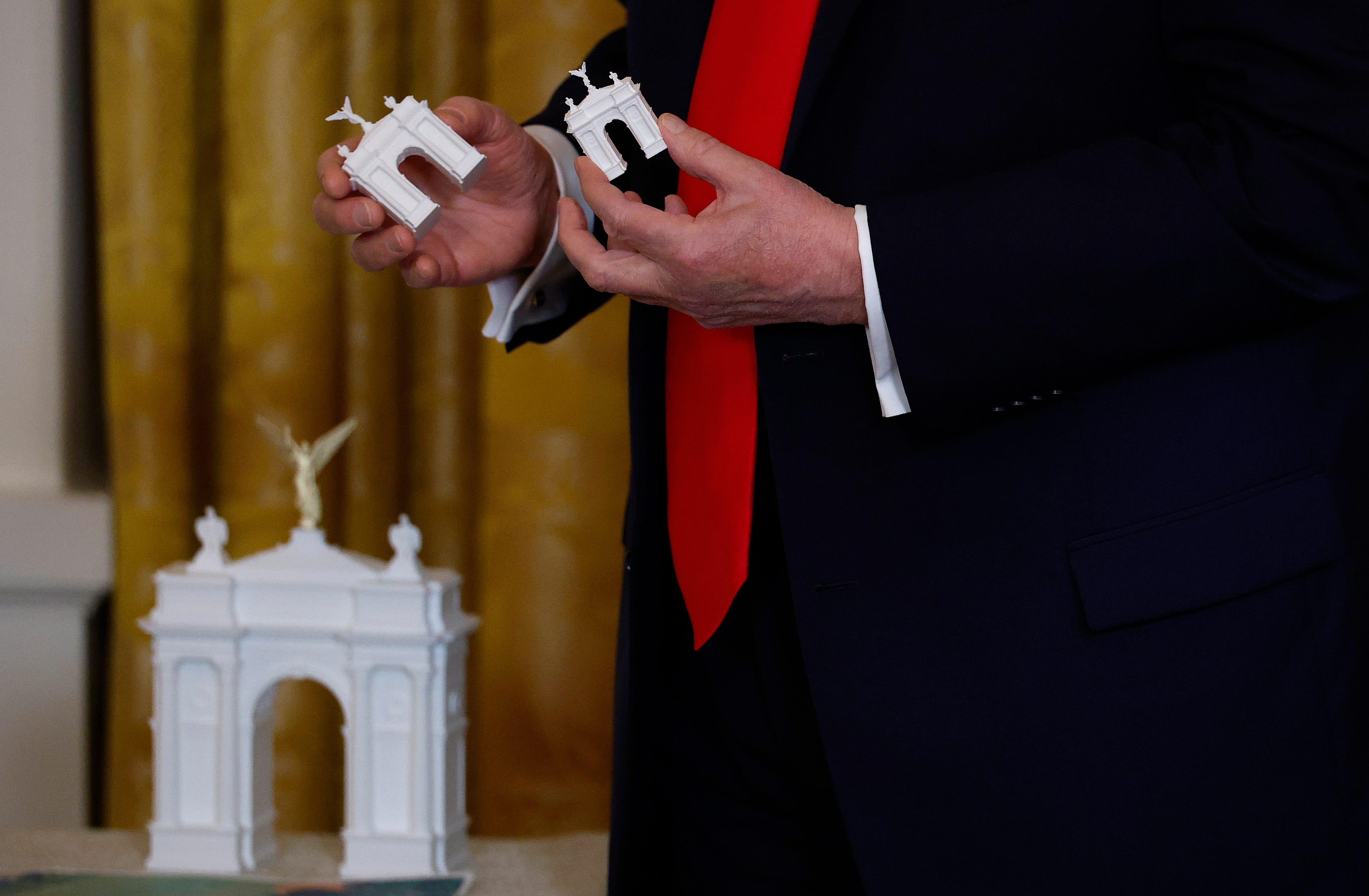 Trump holding a model of the new ballroom.