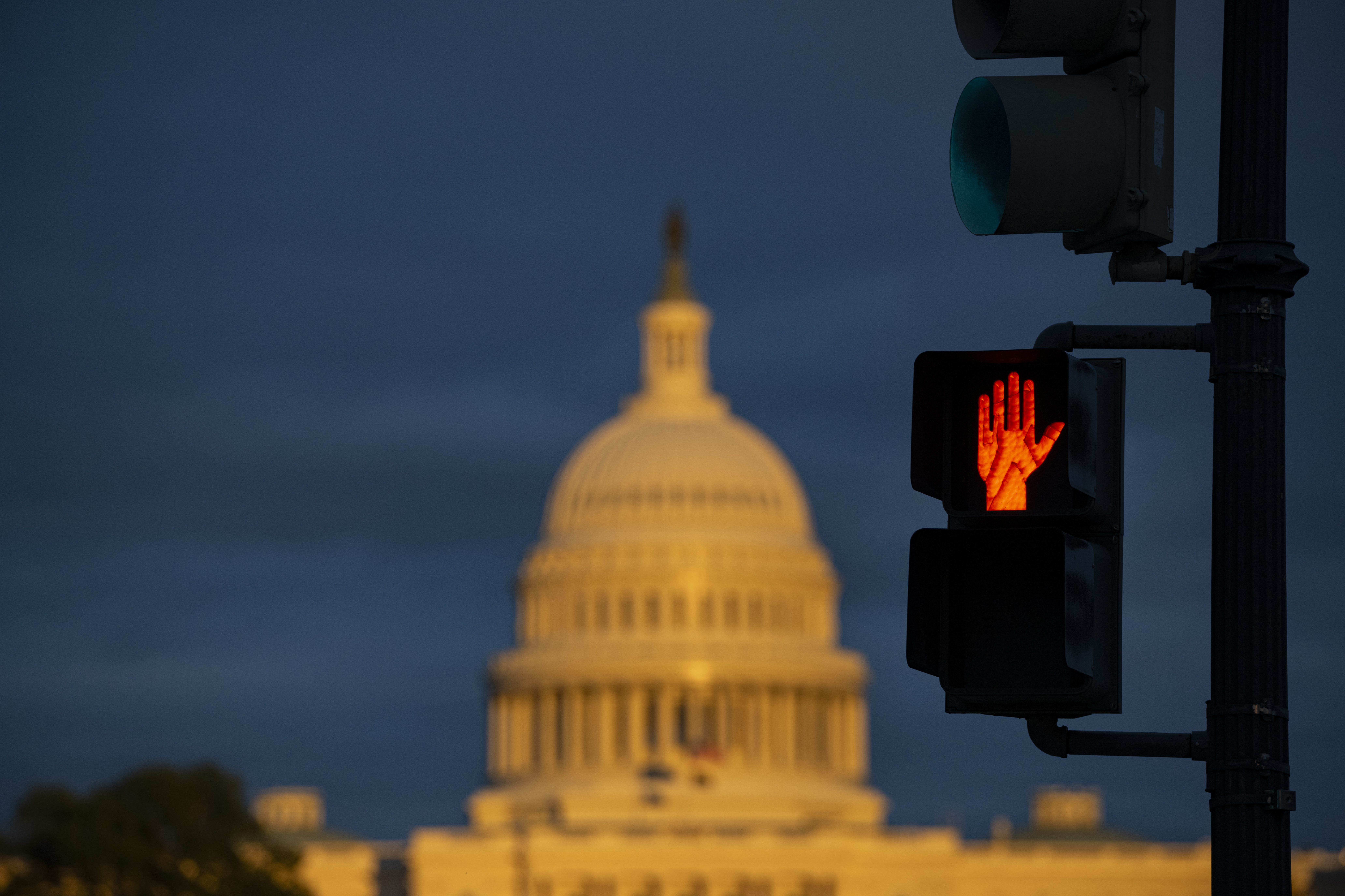 A traffic signal to stop with the Capitol Building in the background