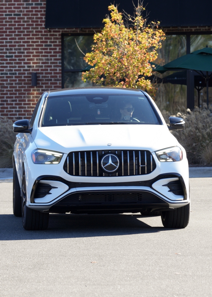 Jordon Hudson in a white Mercedes.