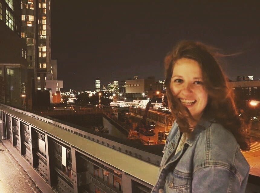 Samanthan Grindell Pettyjohn standing in front of a NYC skyline.