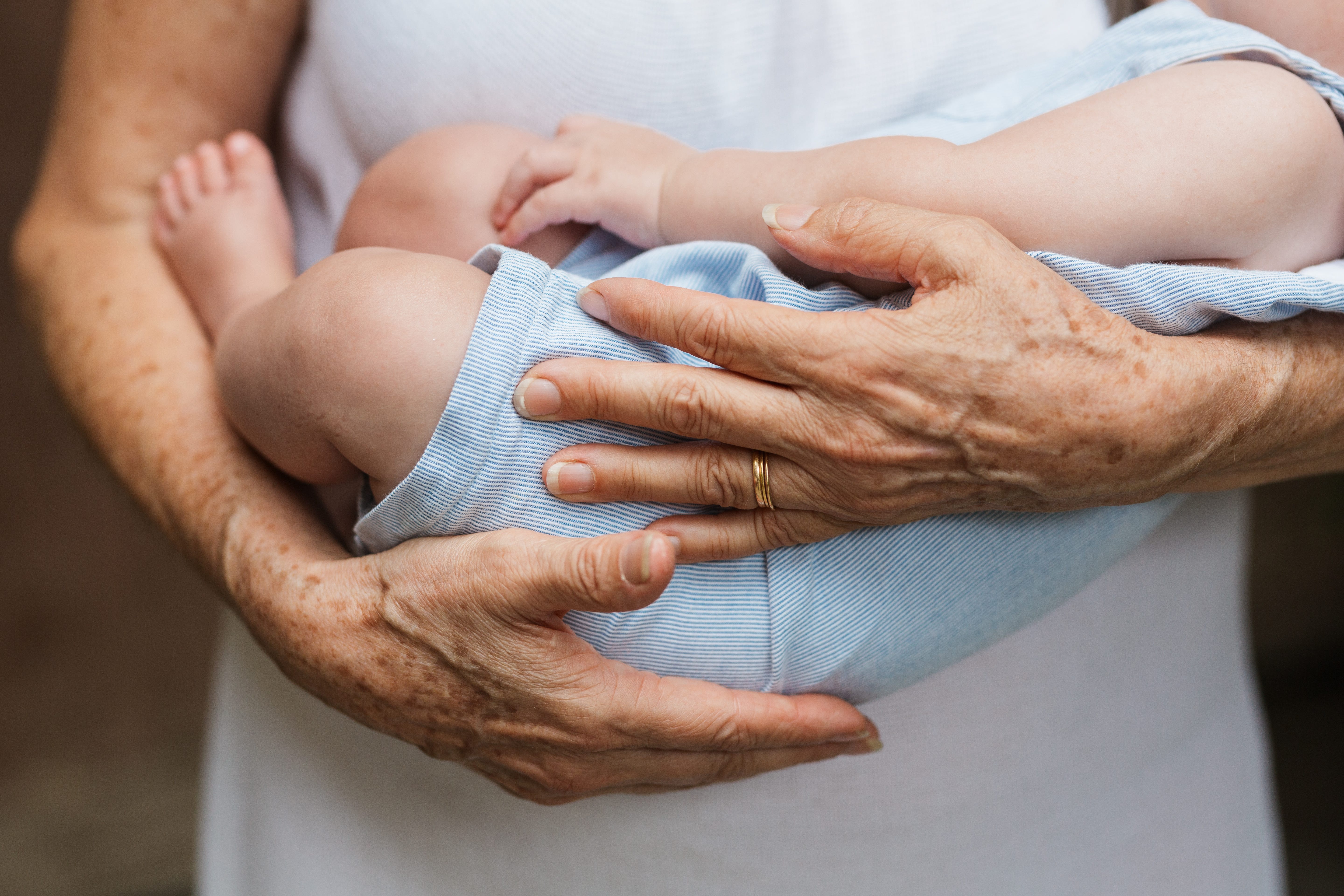 Grandmother holding a grandchild, close-up shot.