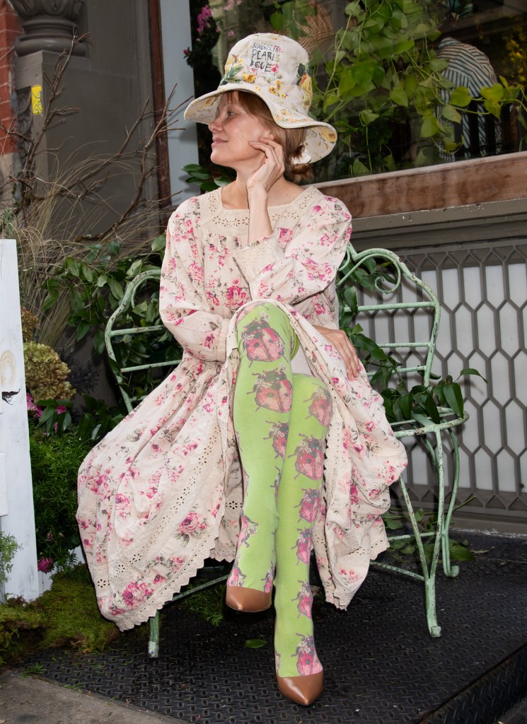 Pamela Anderson sports her best ladybug tights to a garden-themed pop-up event in Soho for her skin care brand.