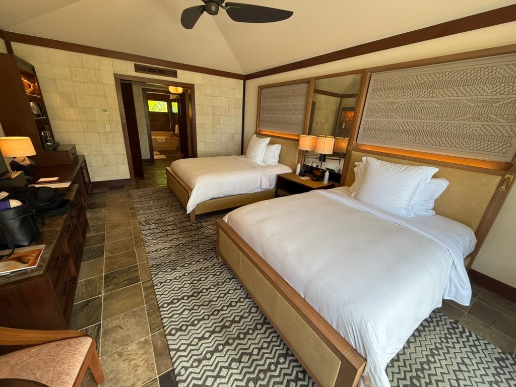 Hotel room with two beds, ceiling fan, white bedding