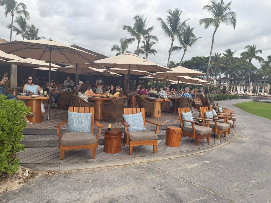 Lounge chairs and umbrellas arranged around dining area