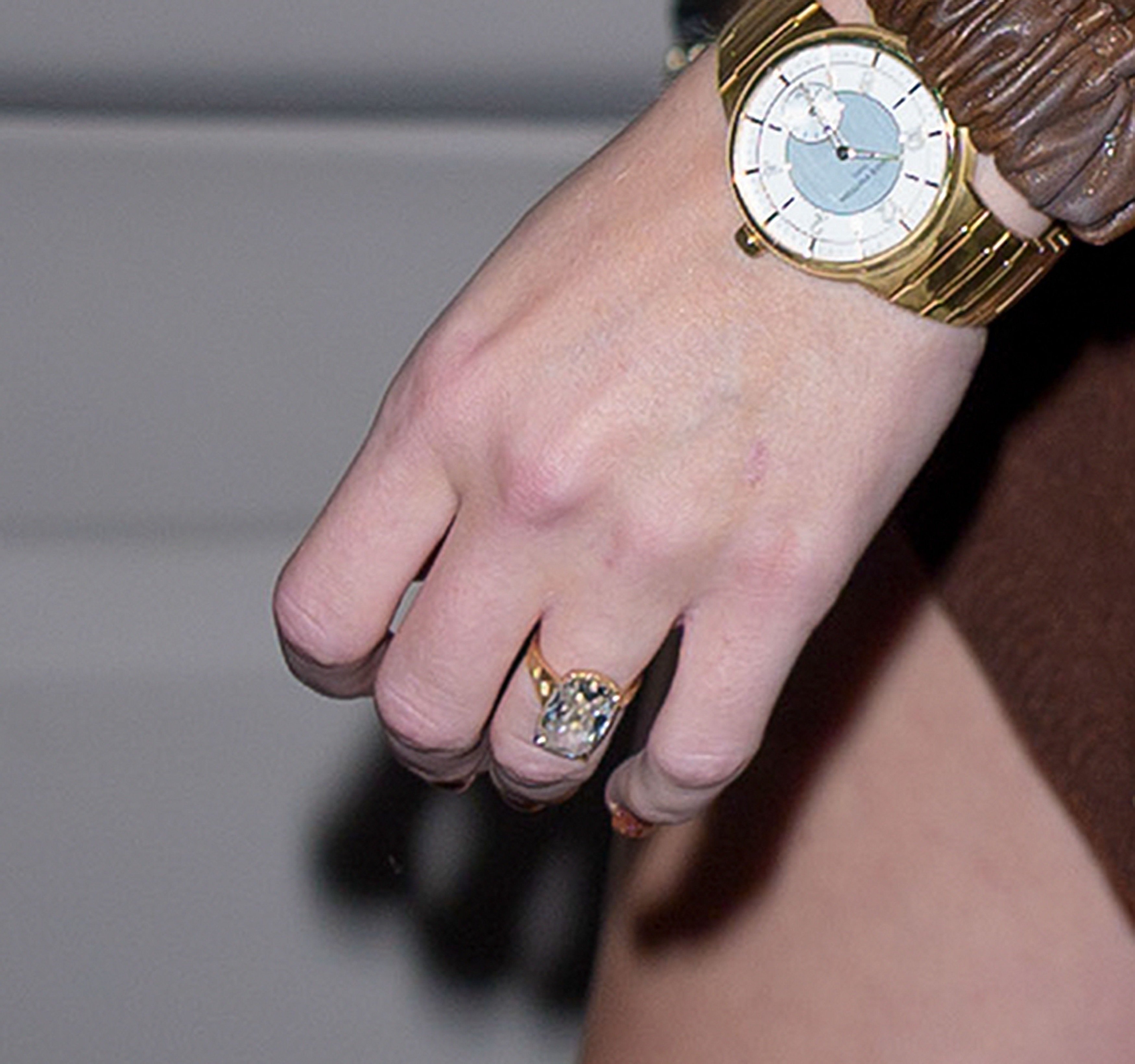 A close-up of Taylor Swift's watch and engagement ring