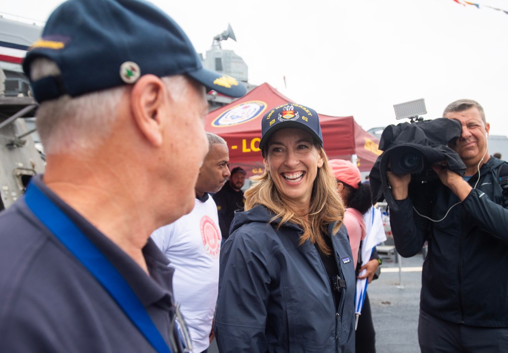 Mikie Sherrill smiling and wearing a USS New Jersey hat.
