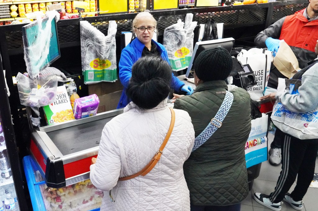 Two women check out at a grocery.