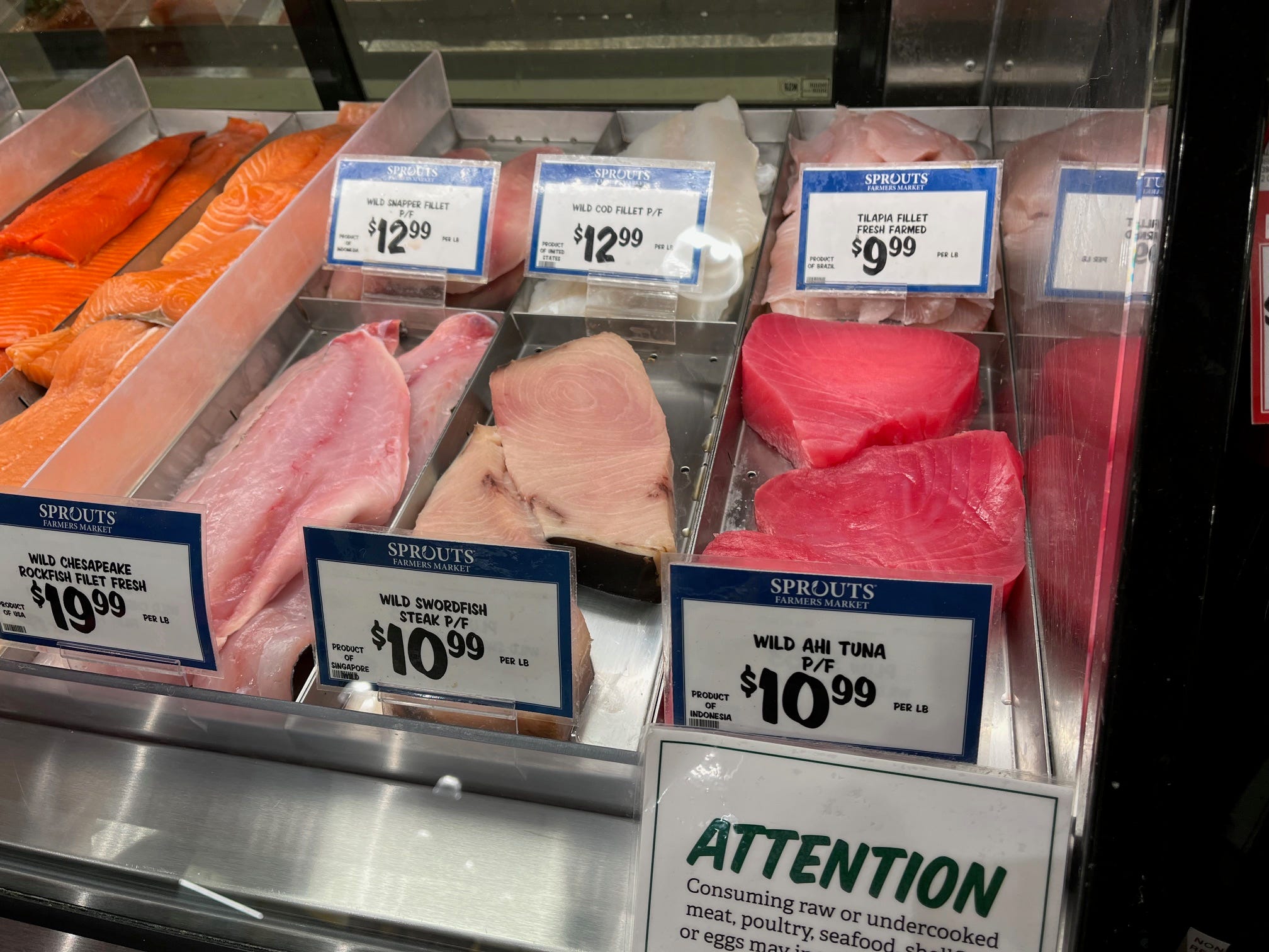 Fish steaks, including Ahi, swordfish, and rockfish, sit in a cooler at Sprouts