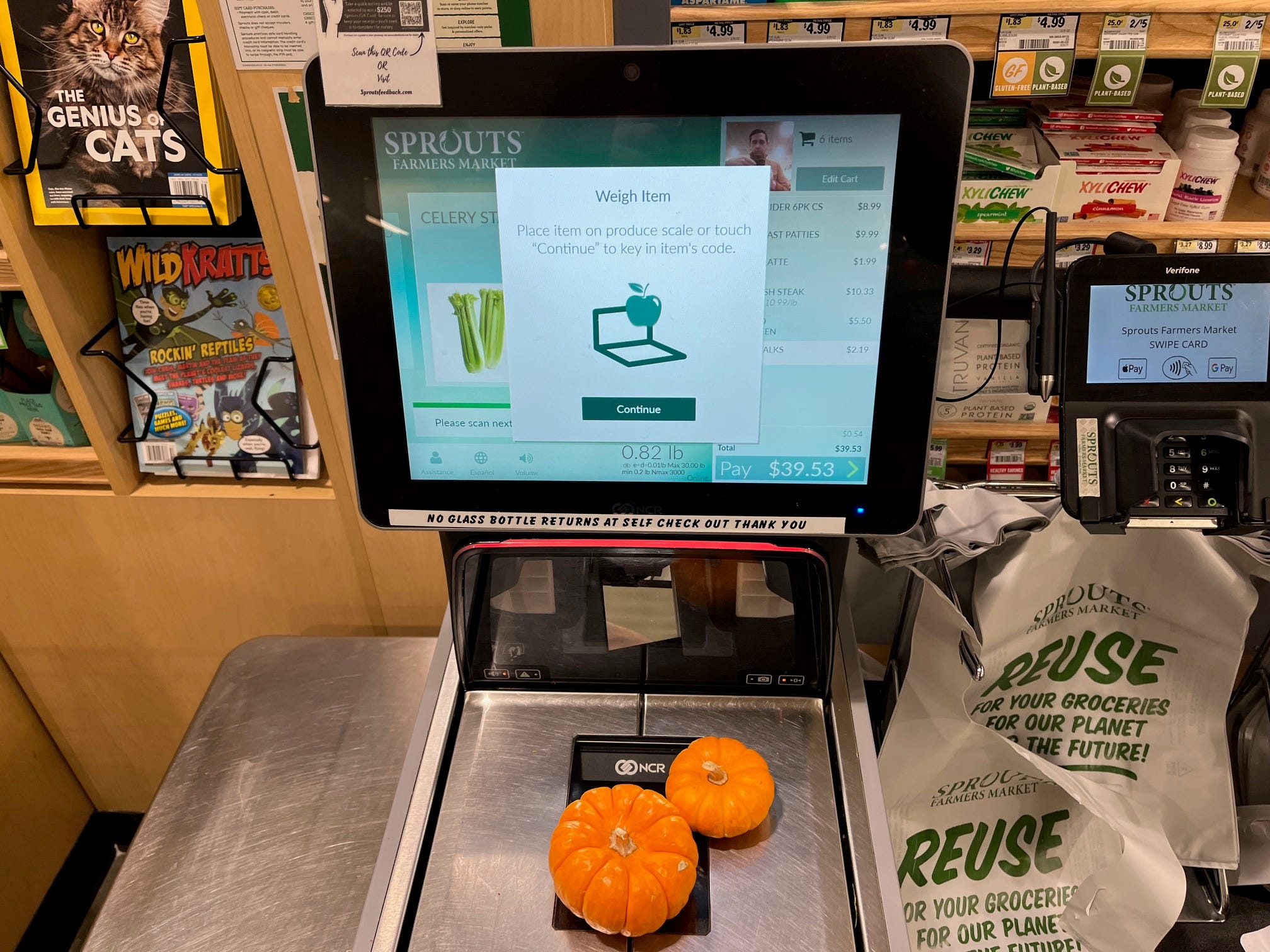 Two mini pumpkins sit on a self-checkout scale at Sprouts