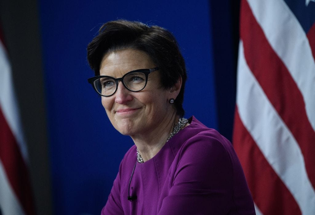 Citi CEO Jane Fraser in front of some American flags wearing a fuchsia top.