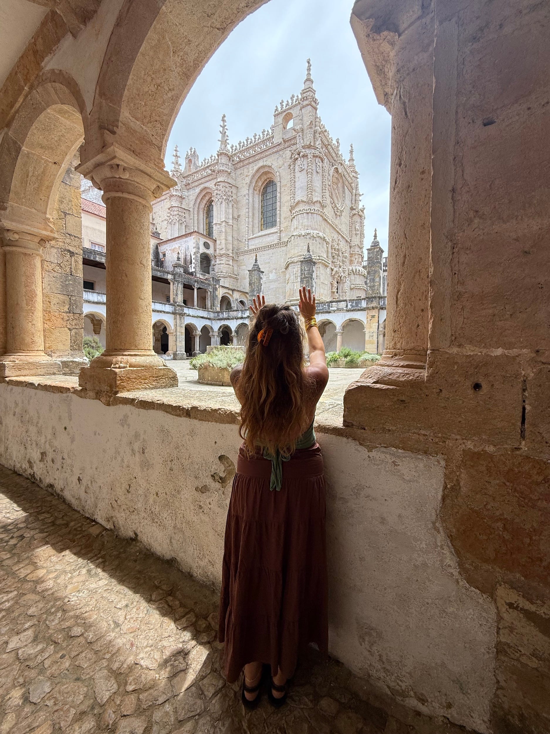 A woman posing in front of a structure in Portugal.