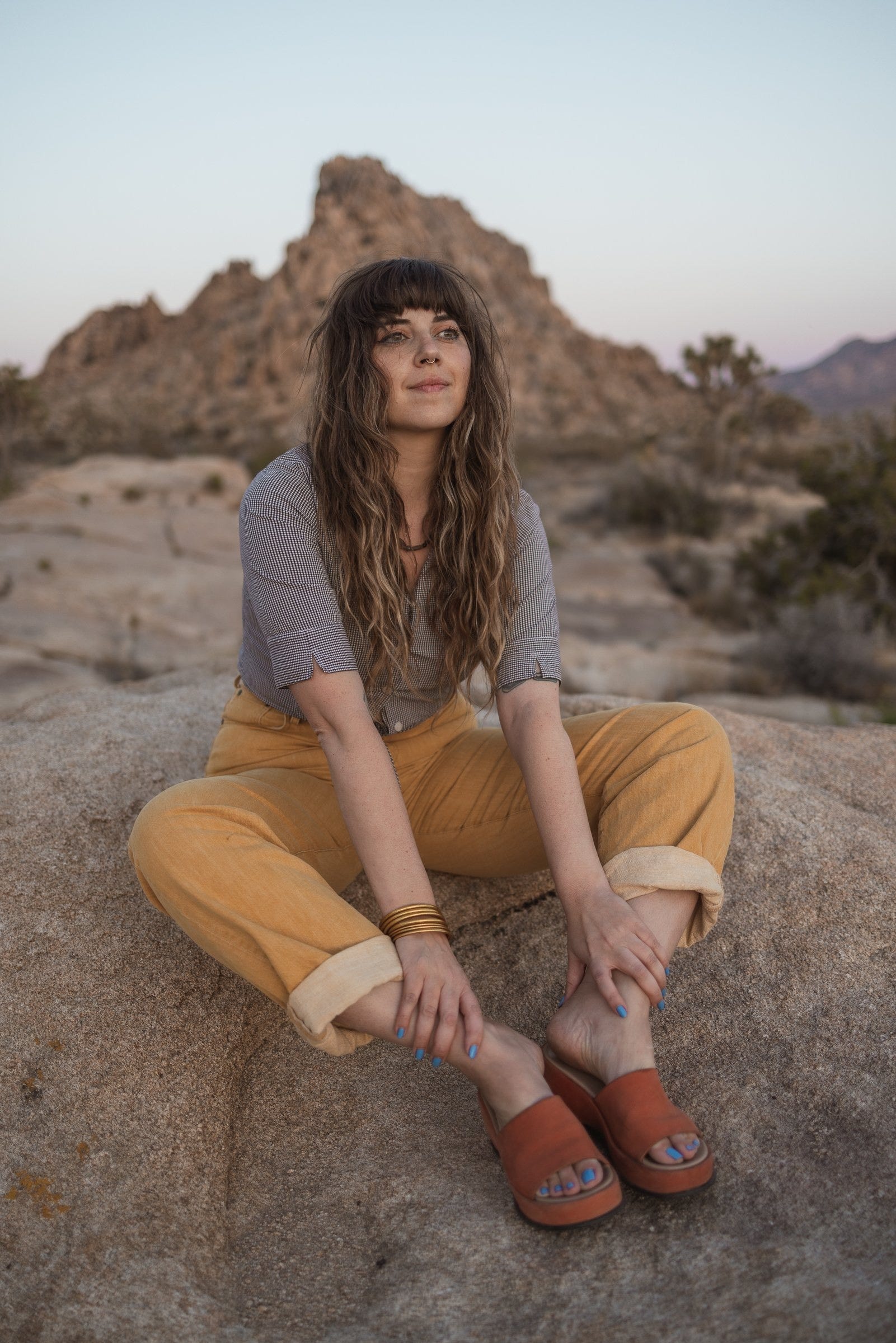 A woman sitting in the desert.