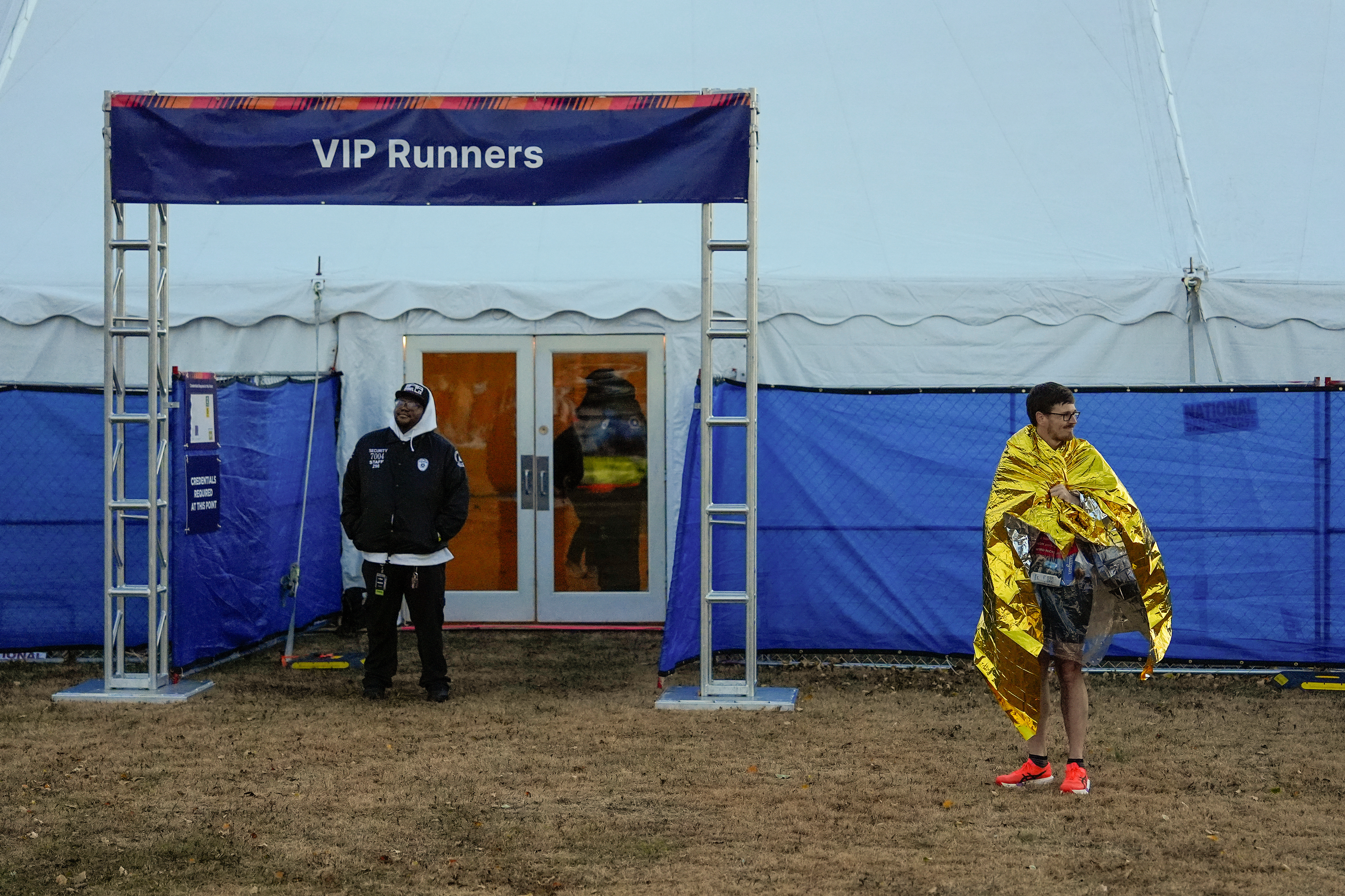 A runner waits near the base of the Verrazzano Narrows Bridge