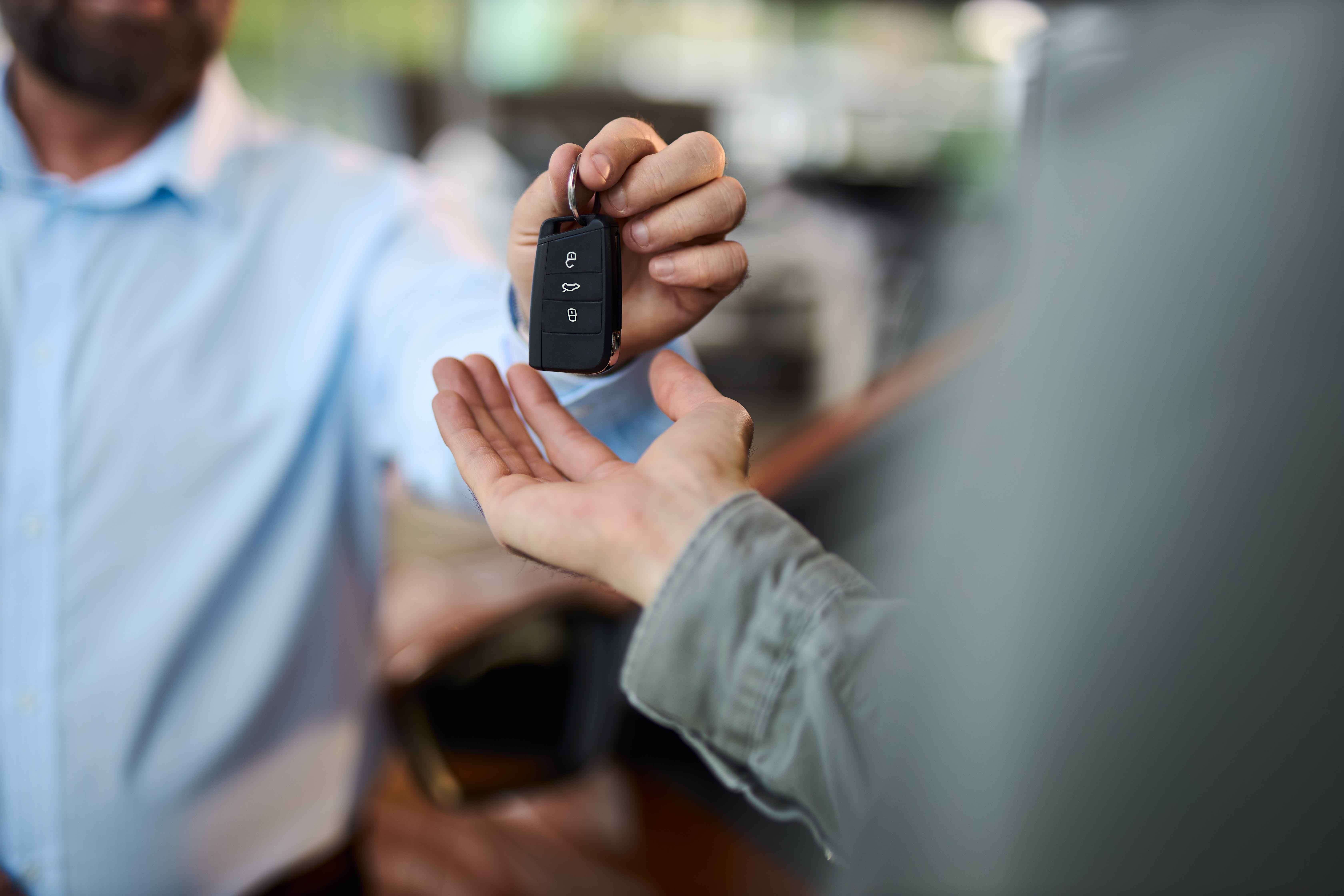 A car key is handed out at a car dealership.