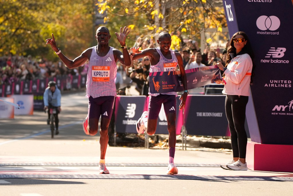 Kenya's Benson Kipruto crosses the finish line ahead of Kenya's Alexander Mutiso to win the men's elite race at the 2025 TCS New York City Marathon.