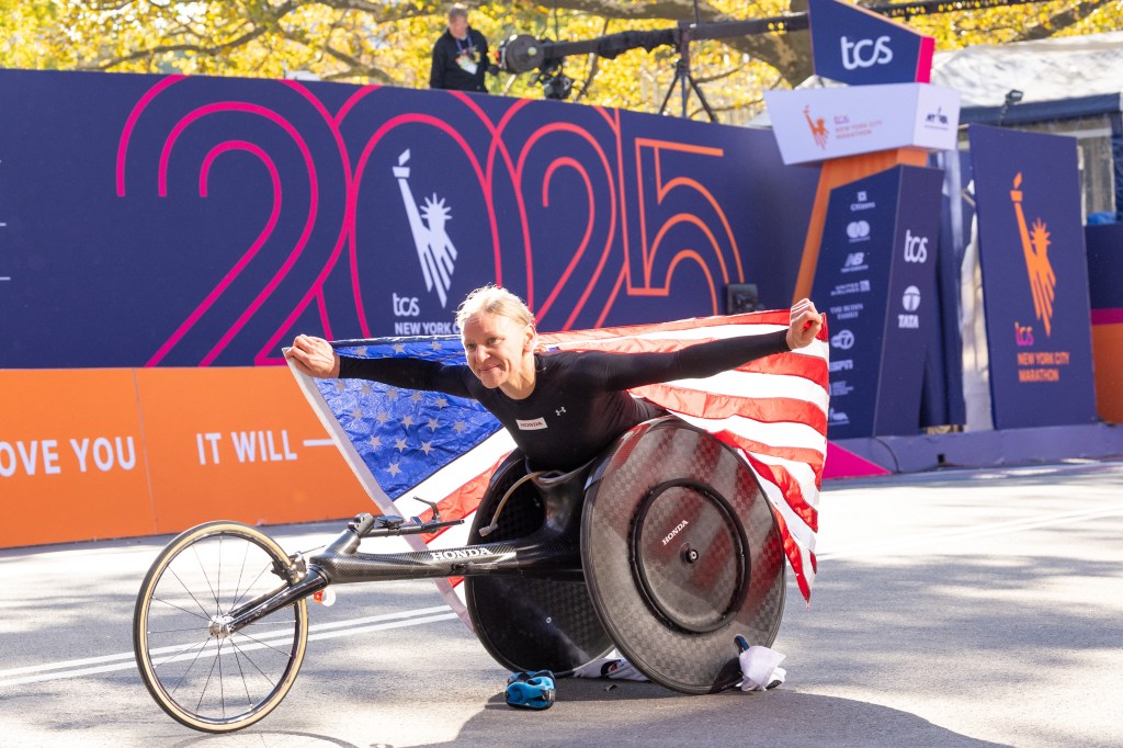 Susannah Scaroni of the United States, wearing an American flag, finishes first in the Women's Pro Wheelchair Division of the New York City Marathon.
