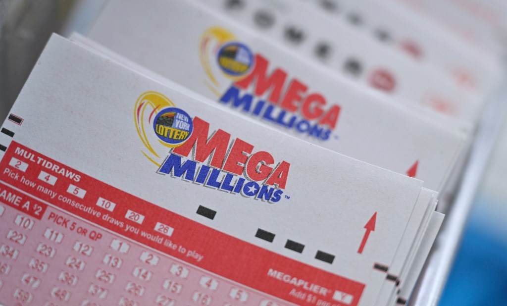 A stack of Mega Millions lottery tickets, with the New York Lottery logo visible on the top ticket.