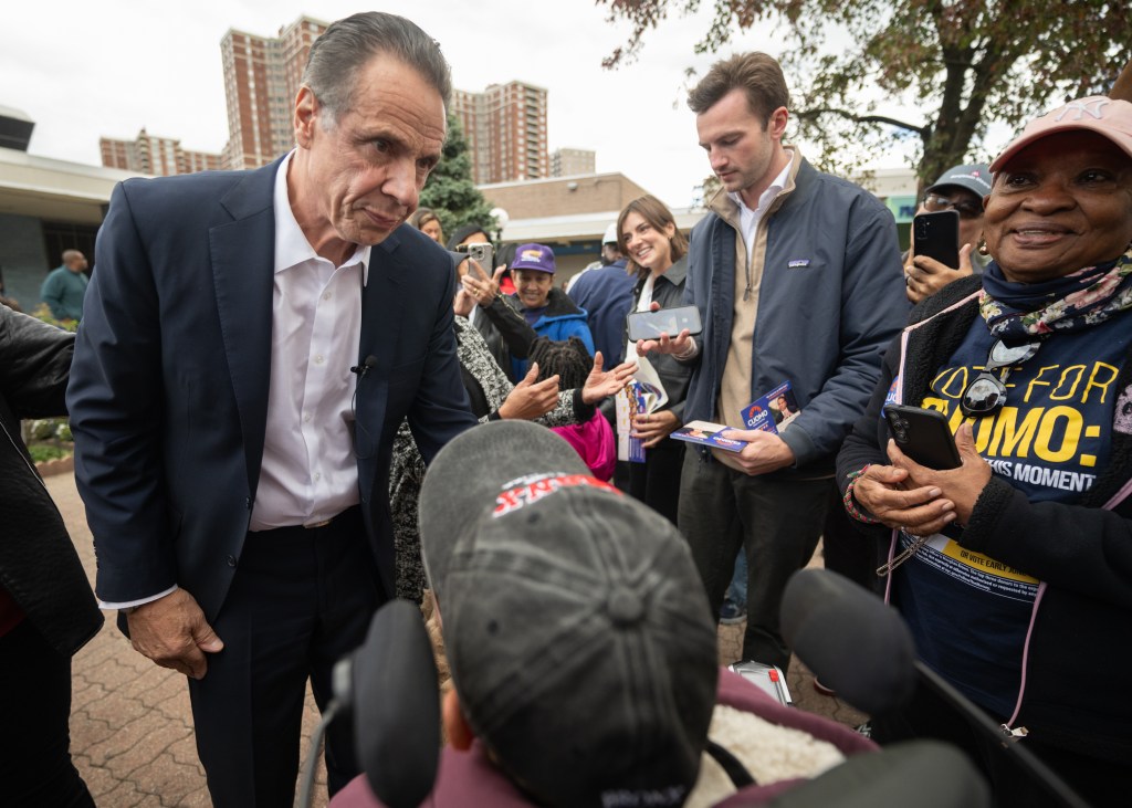 Andrew Cuomo interacting with a young person in a crowd.