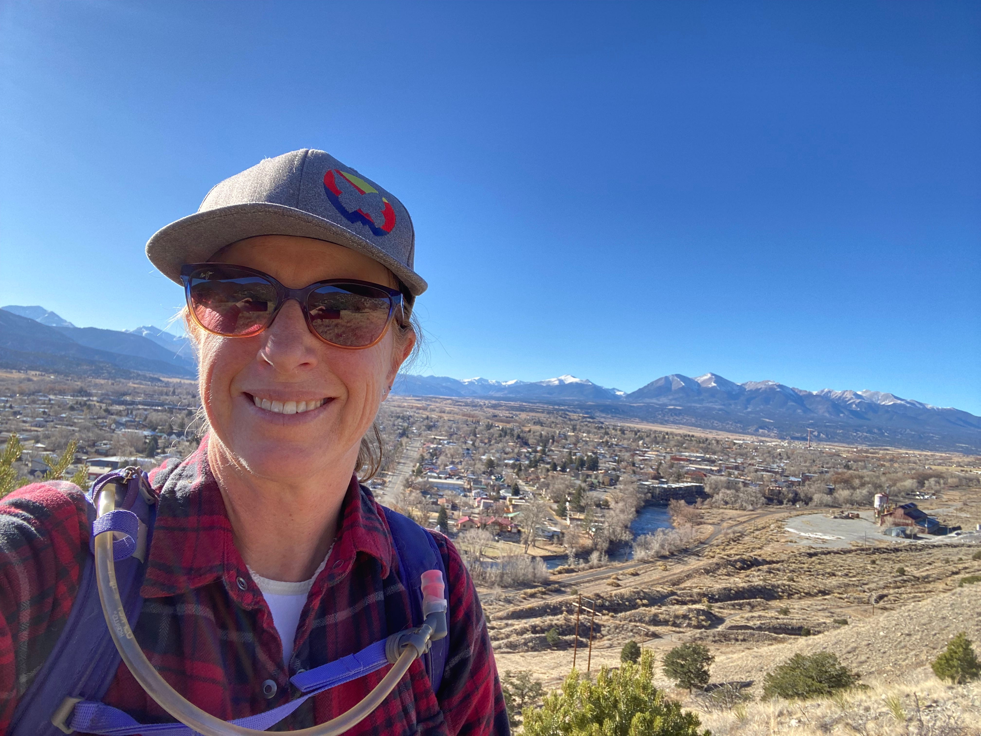 Author Becki Rupp smiling with mountains in distance
