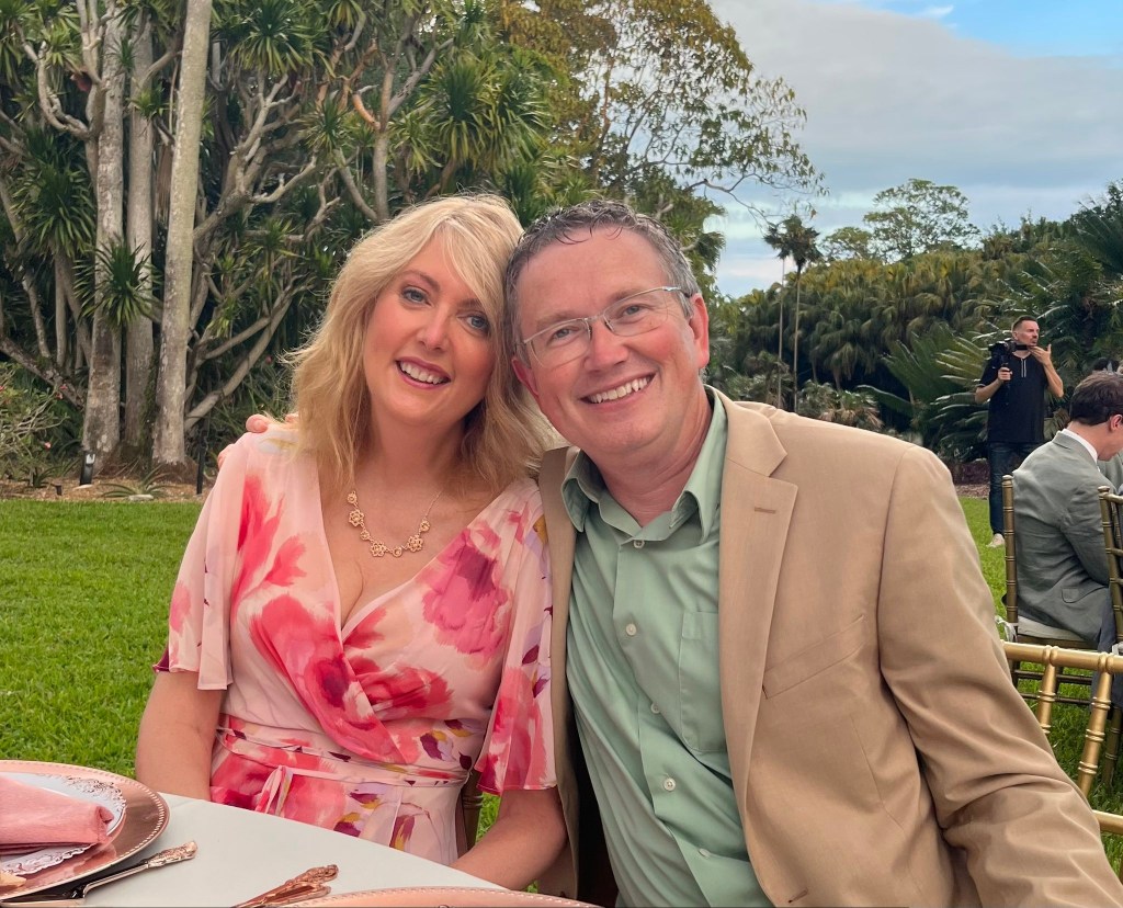 Representative Thomas Massie with his new wife, Carolyn Grace Moffa, both smiling at the camera at an outdoor event.