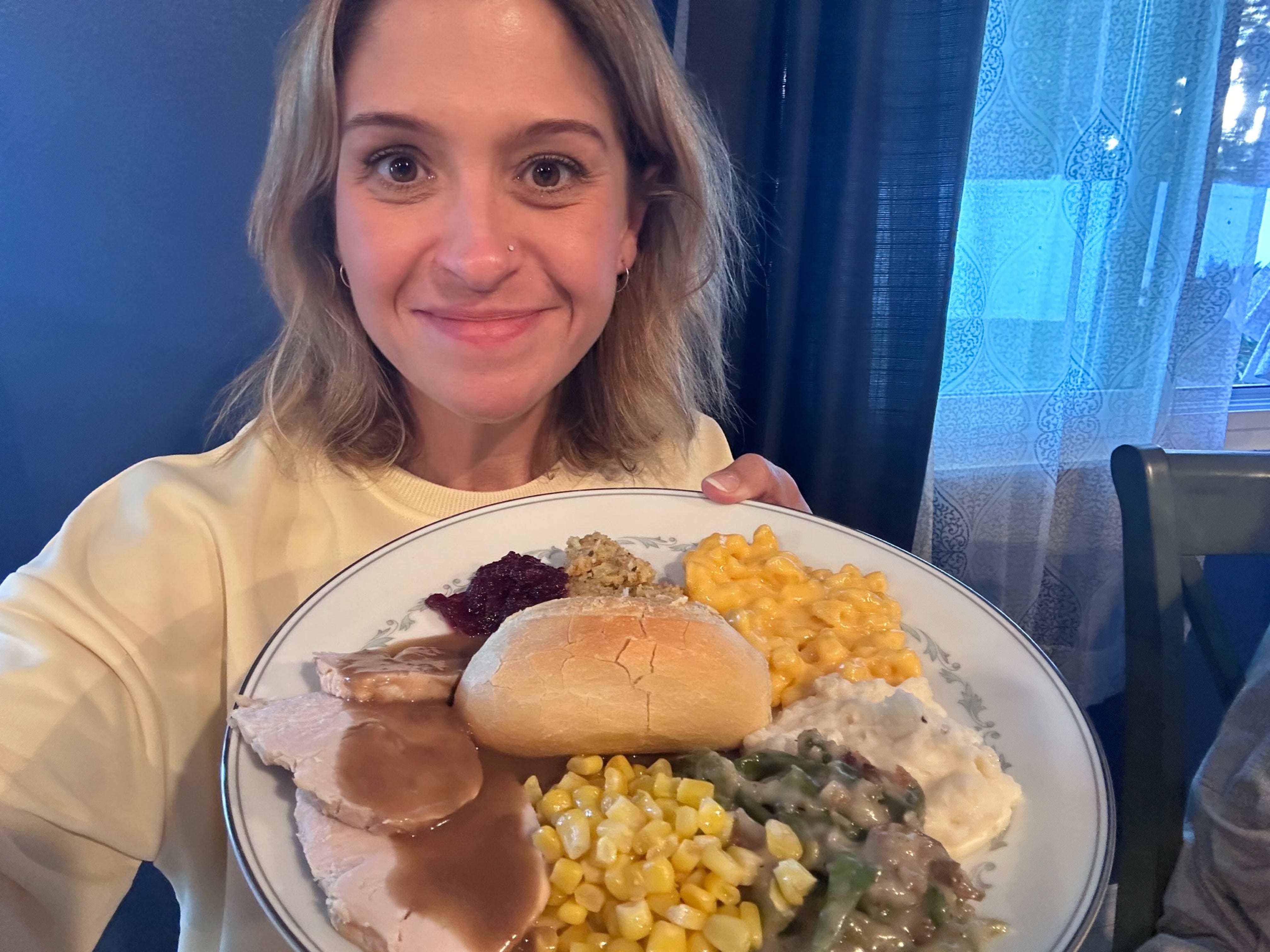 The author holding plate of Thanksgiving food.