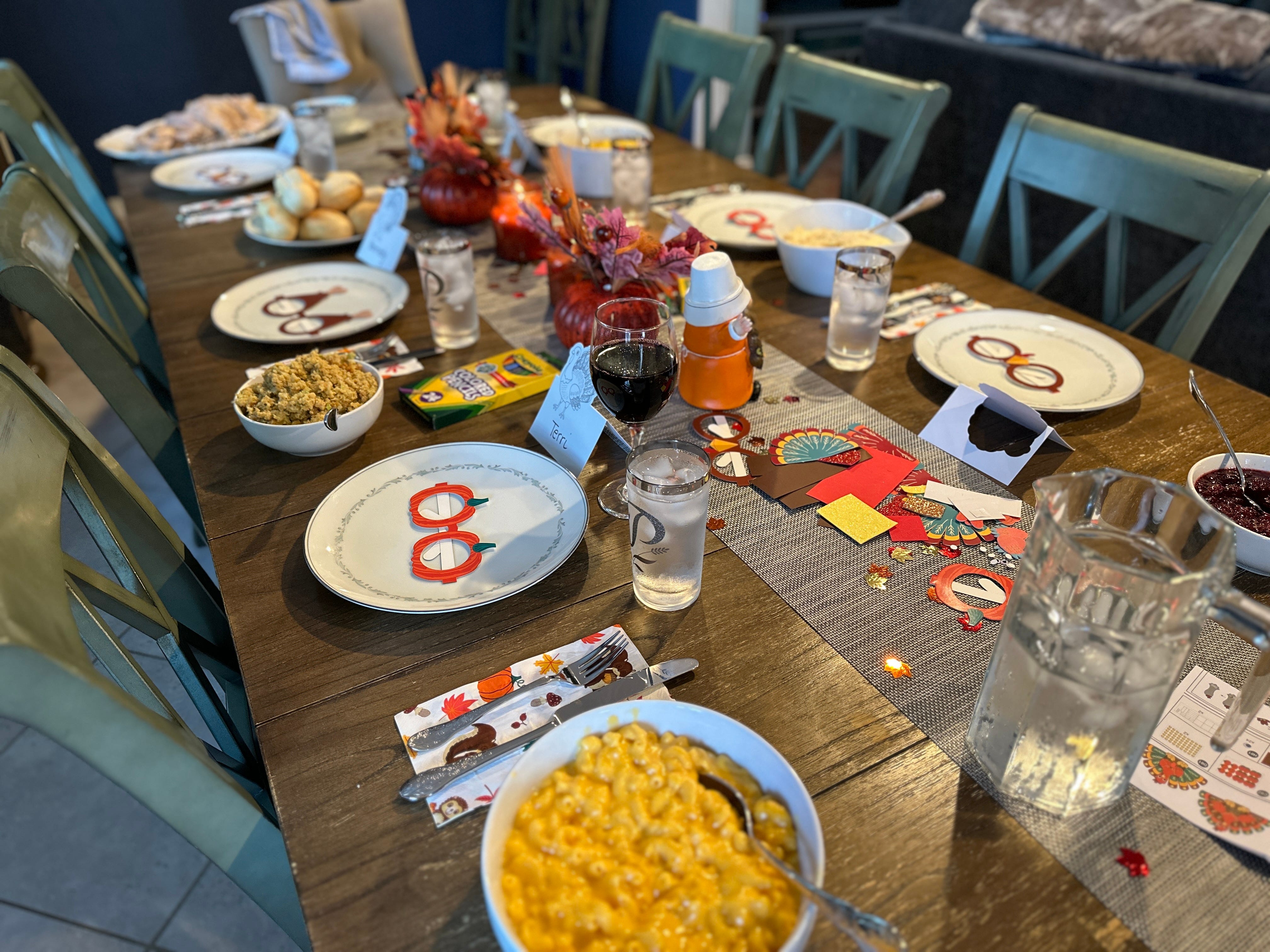 Thanksgiving table set up with name cards and dishes with serving spoons