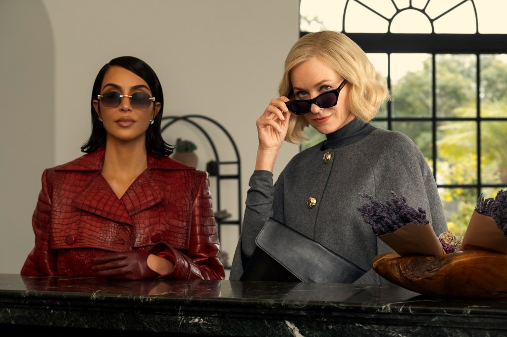 Kim Kardashian in a red alligator-skin jacket and Naomi Watts in a gray cape and sunglasses.