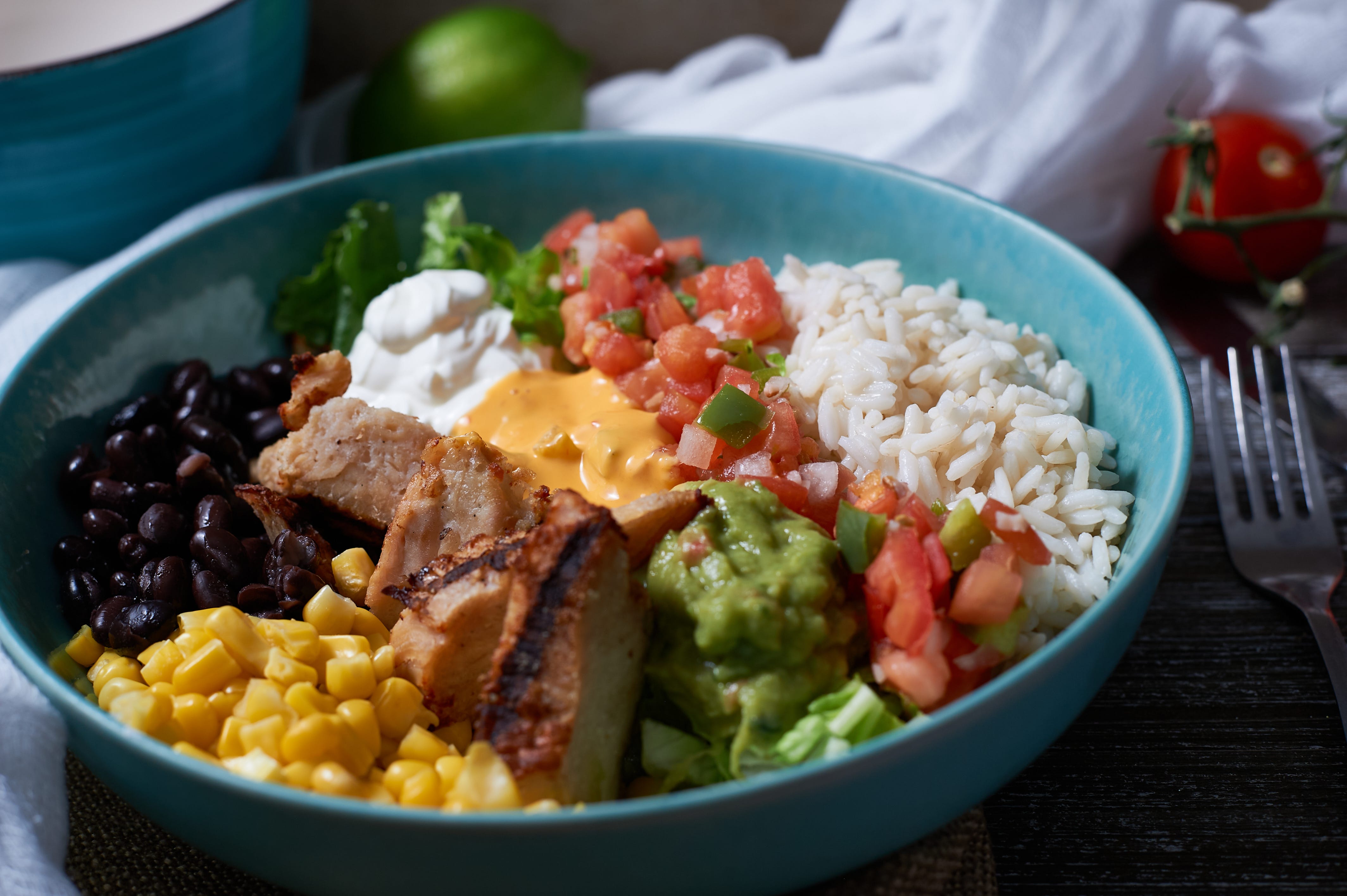 Rice bowl with chicken, tomato, avocado, corn, beans