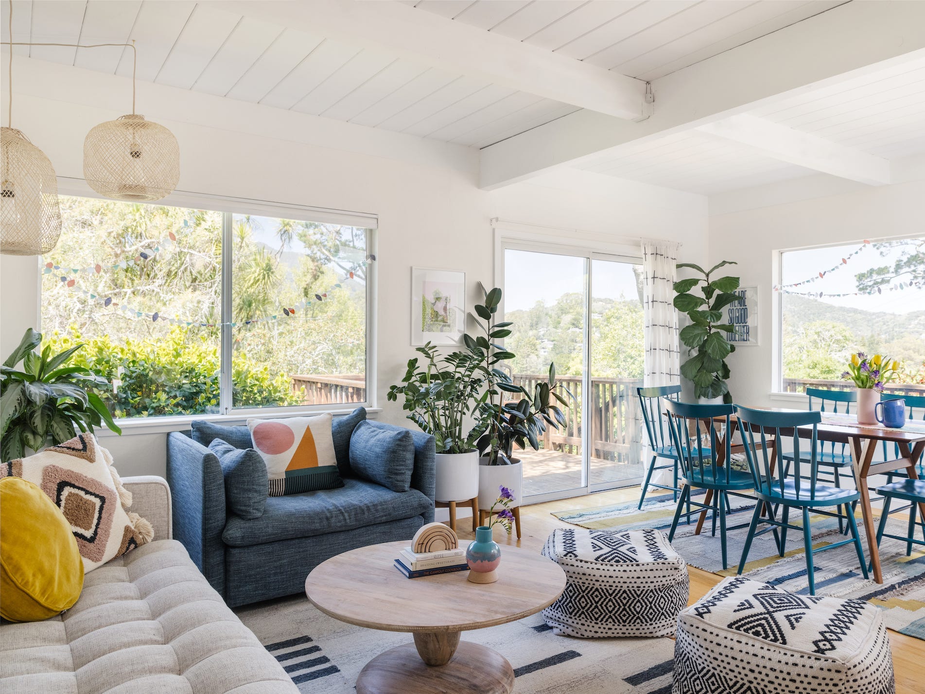 A living area with couches and chairs on a rug and then a table on a different rug.