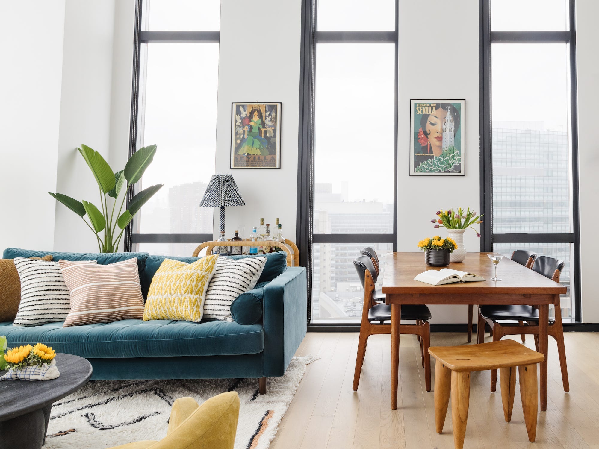 An open concept living area with a couch on top of a rug and a dining table.