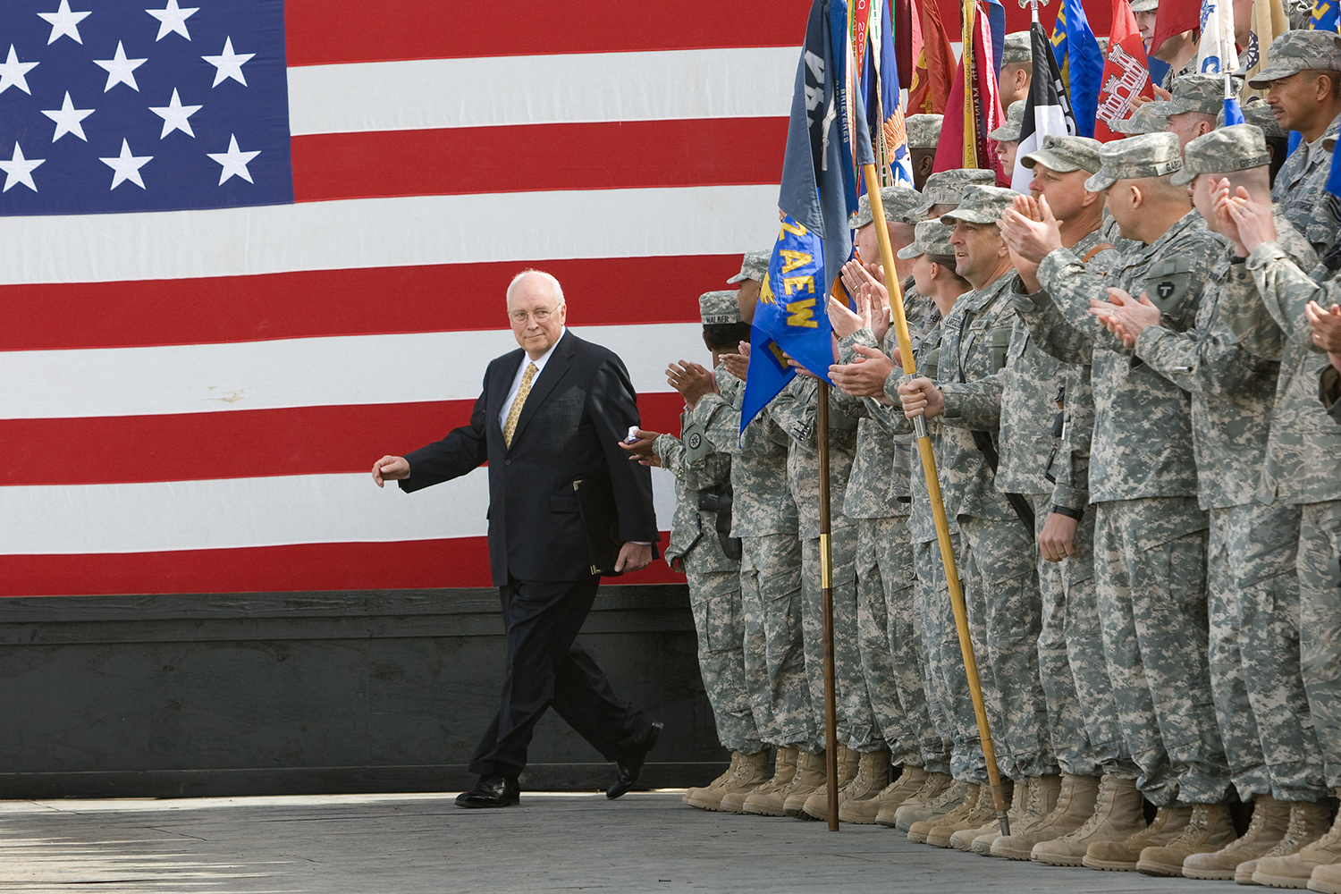 Dick Cheney walks next to troops.