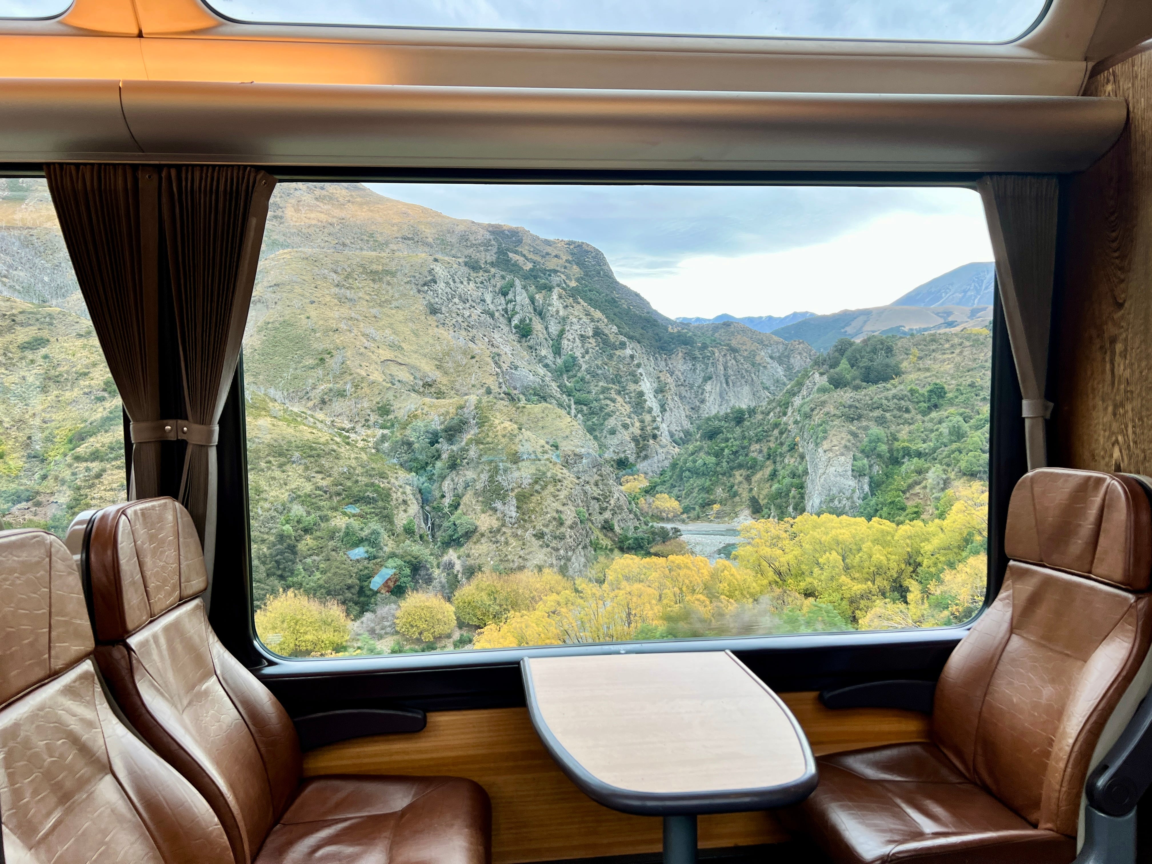 View of trees, mountains from window on TranzAlpine train