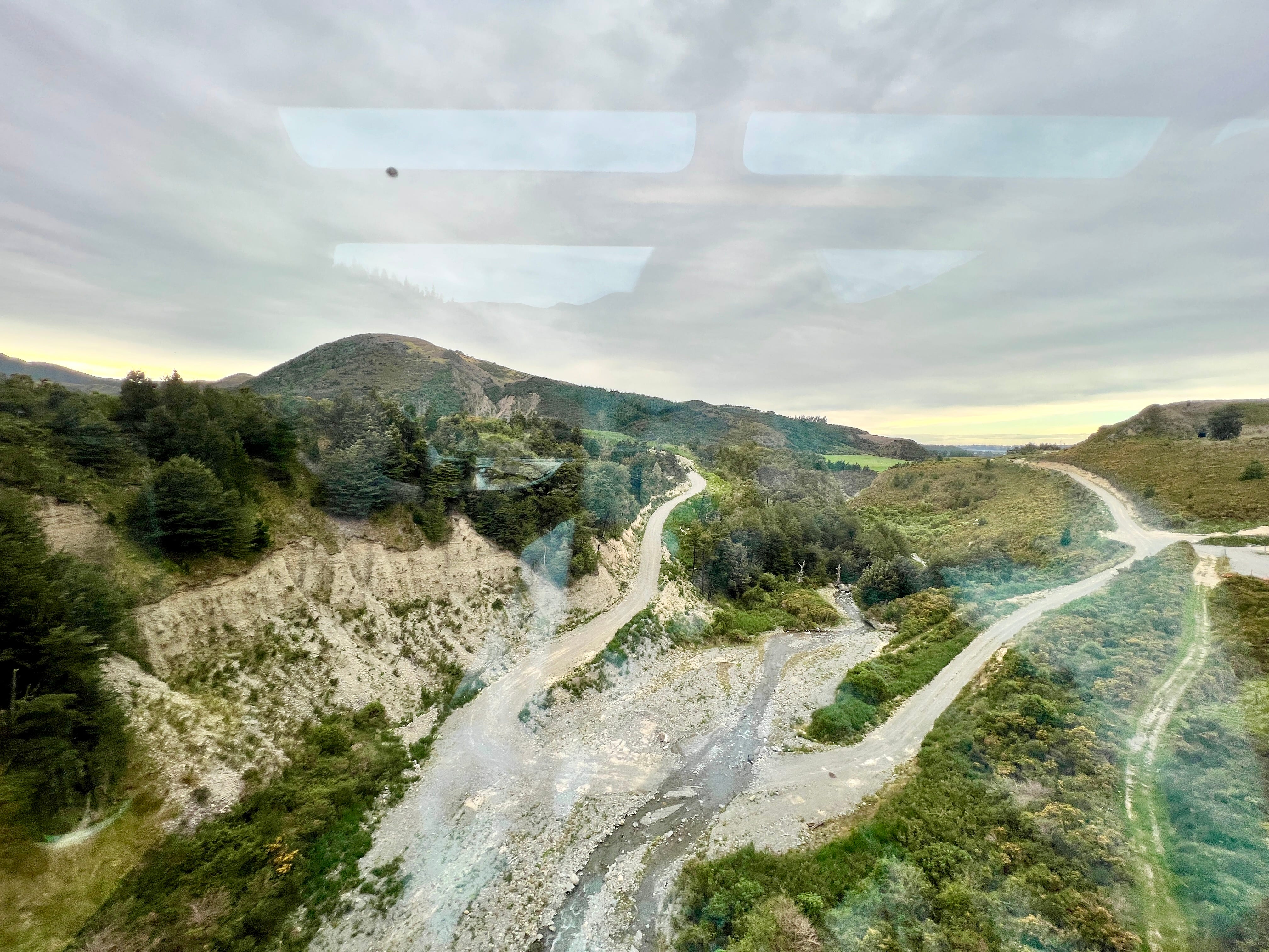 View of trees, mountains, with glare of window visible on photo