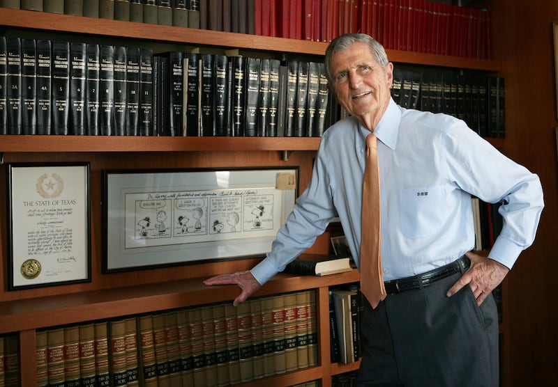 Harry Whittington poses by a bookshelf.
