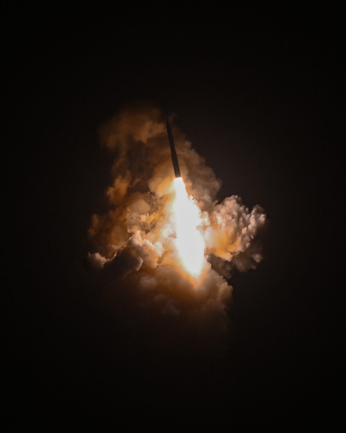 A Minuteman III missile surrounded by clouds of smoke.